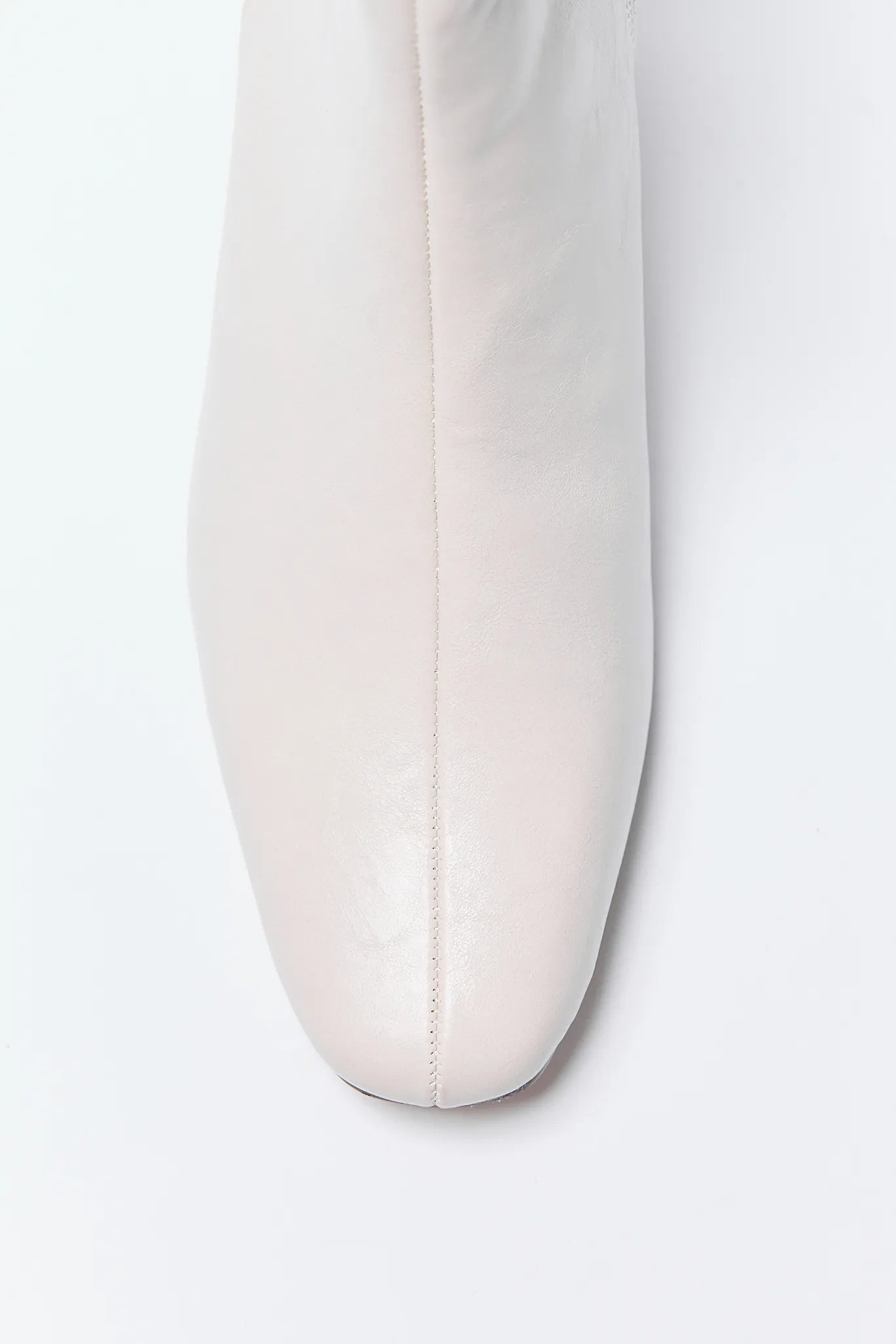 Close-up of a white Adler Boots on a light gray background