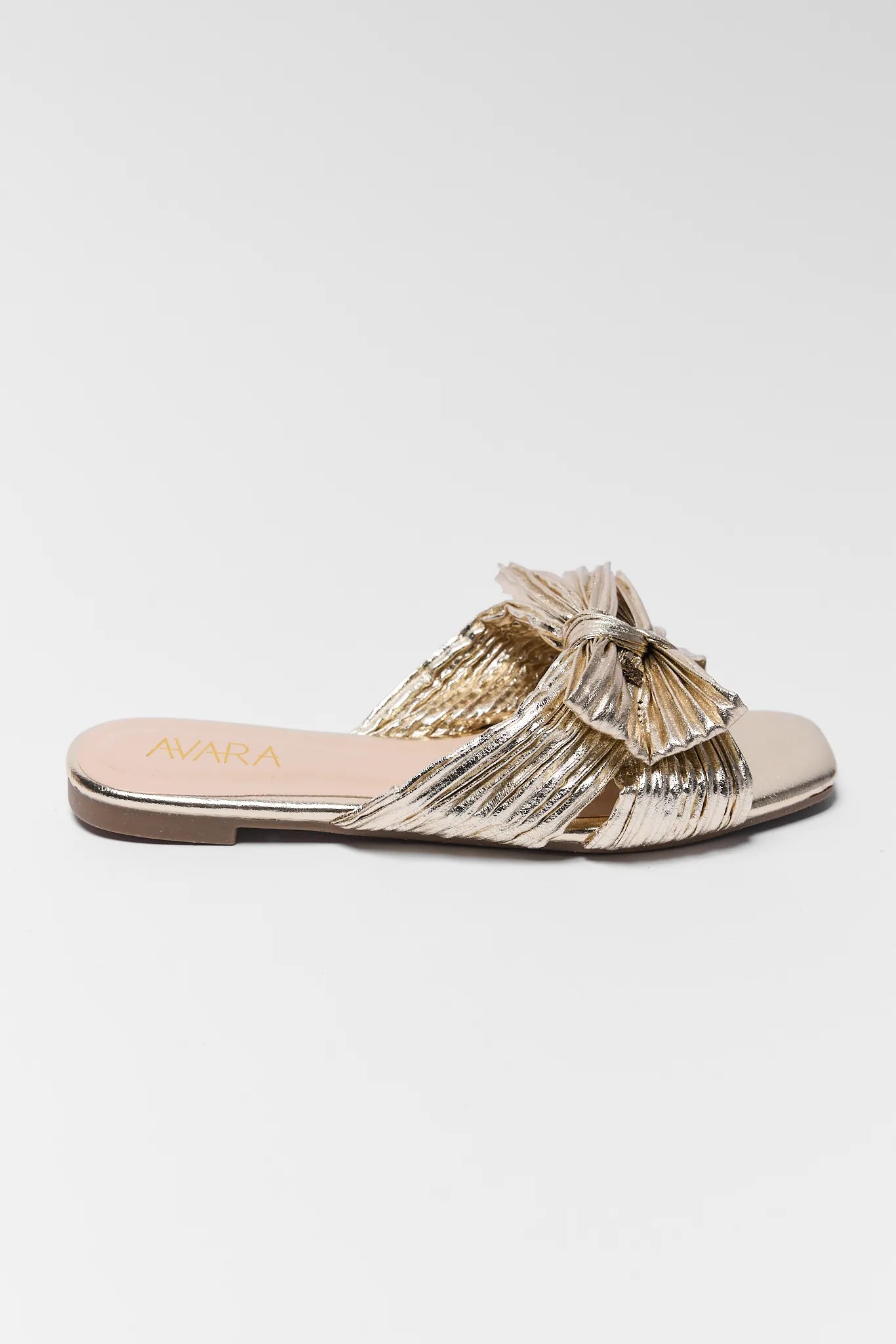 Gold metallic sandal with bow on a white background