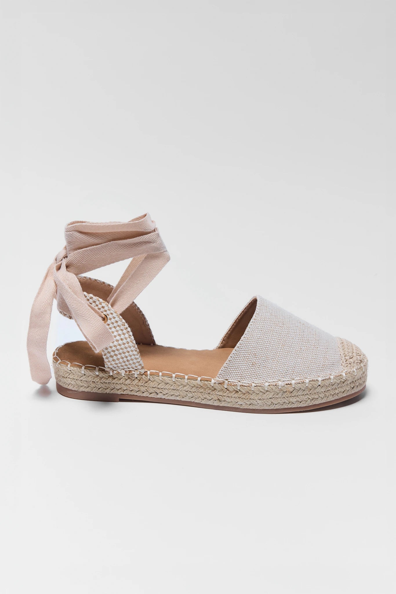 one beige sandal with espadrille sole on a light gray background