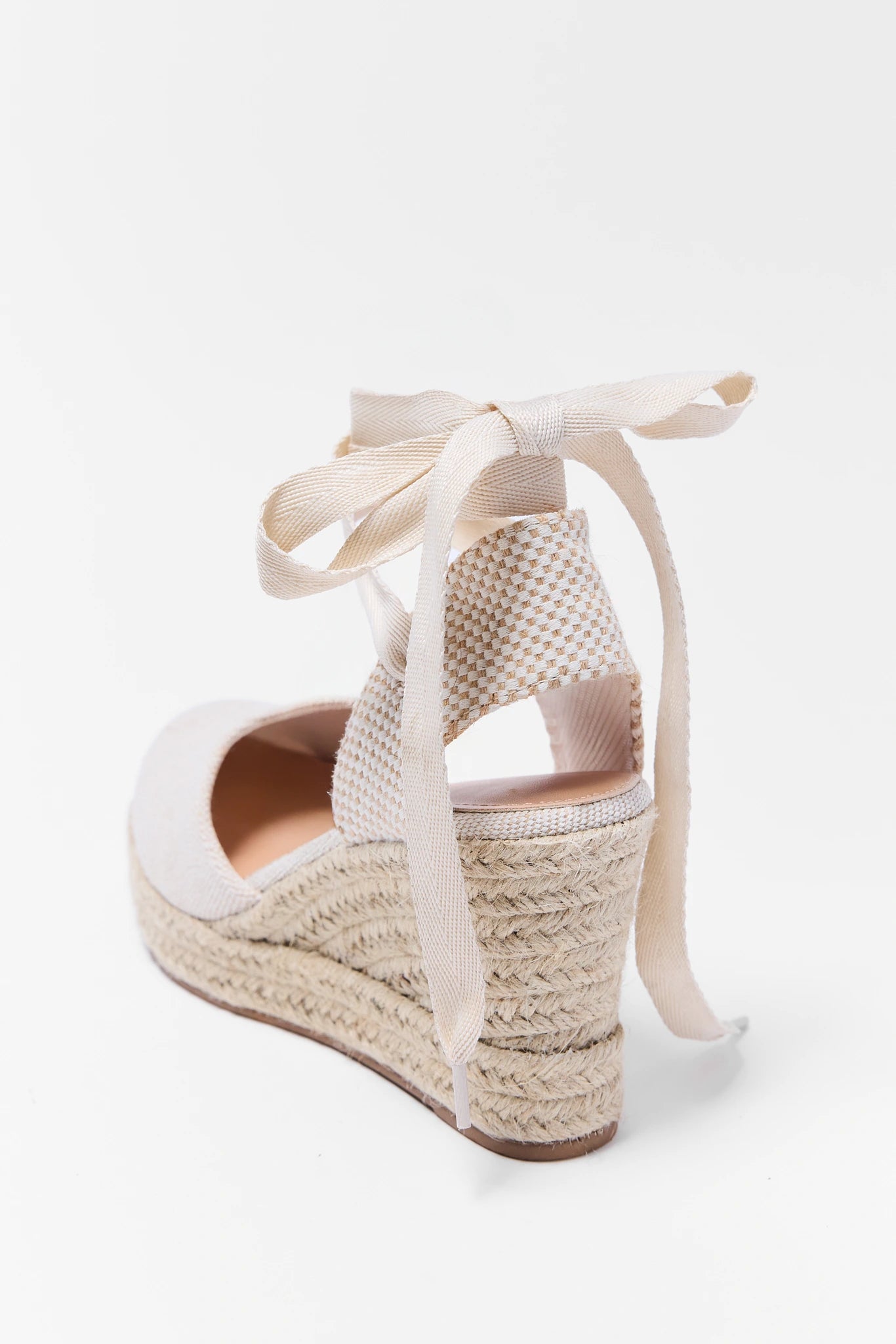 White wedge sandal with raffia sole on a white background