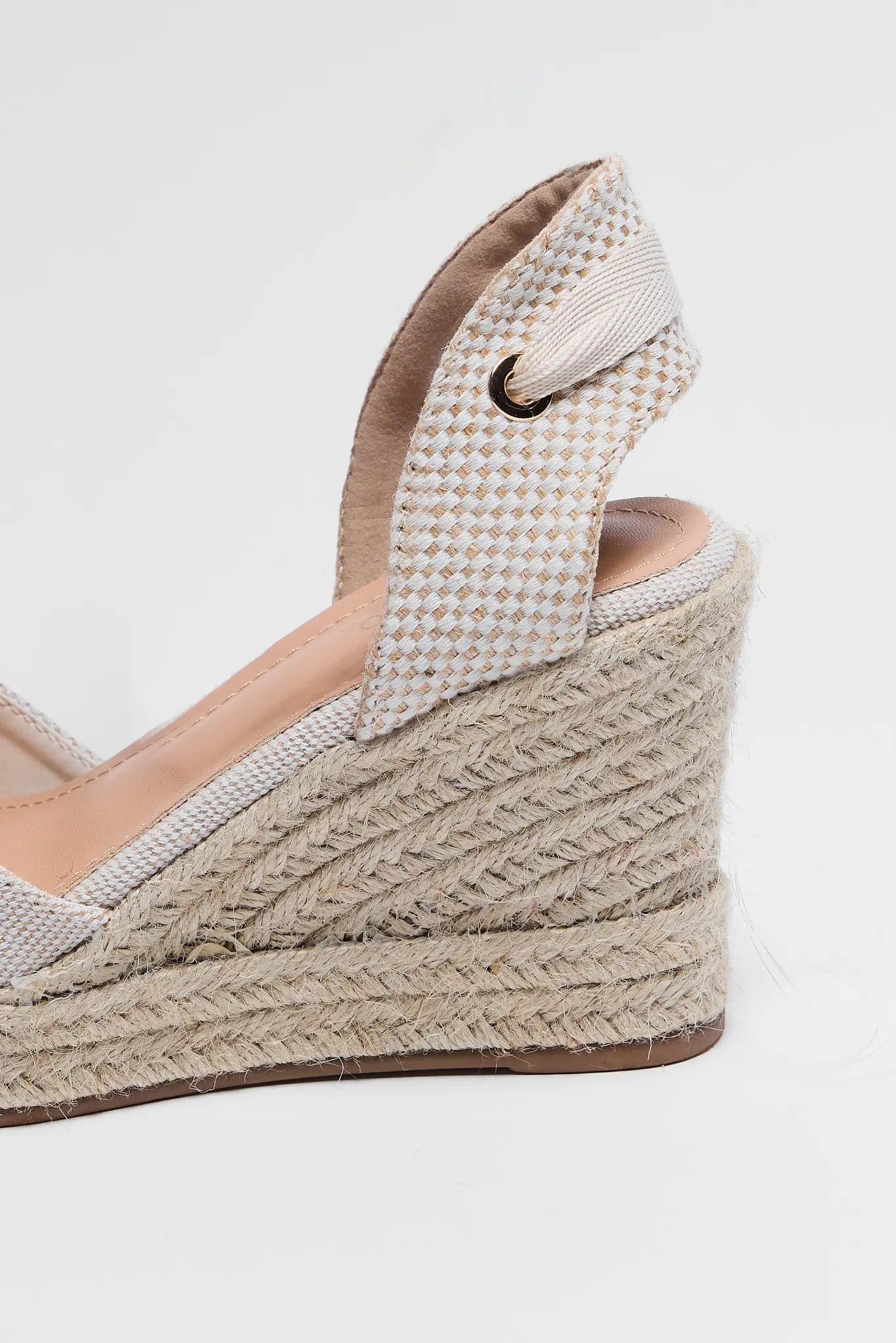 Wedge sandal with woven wedge and textured strap on a white background