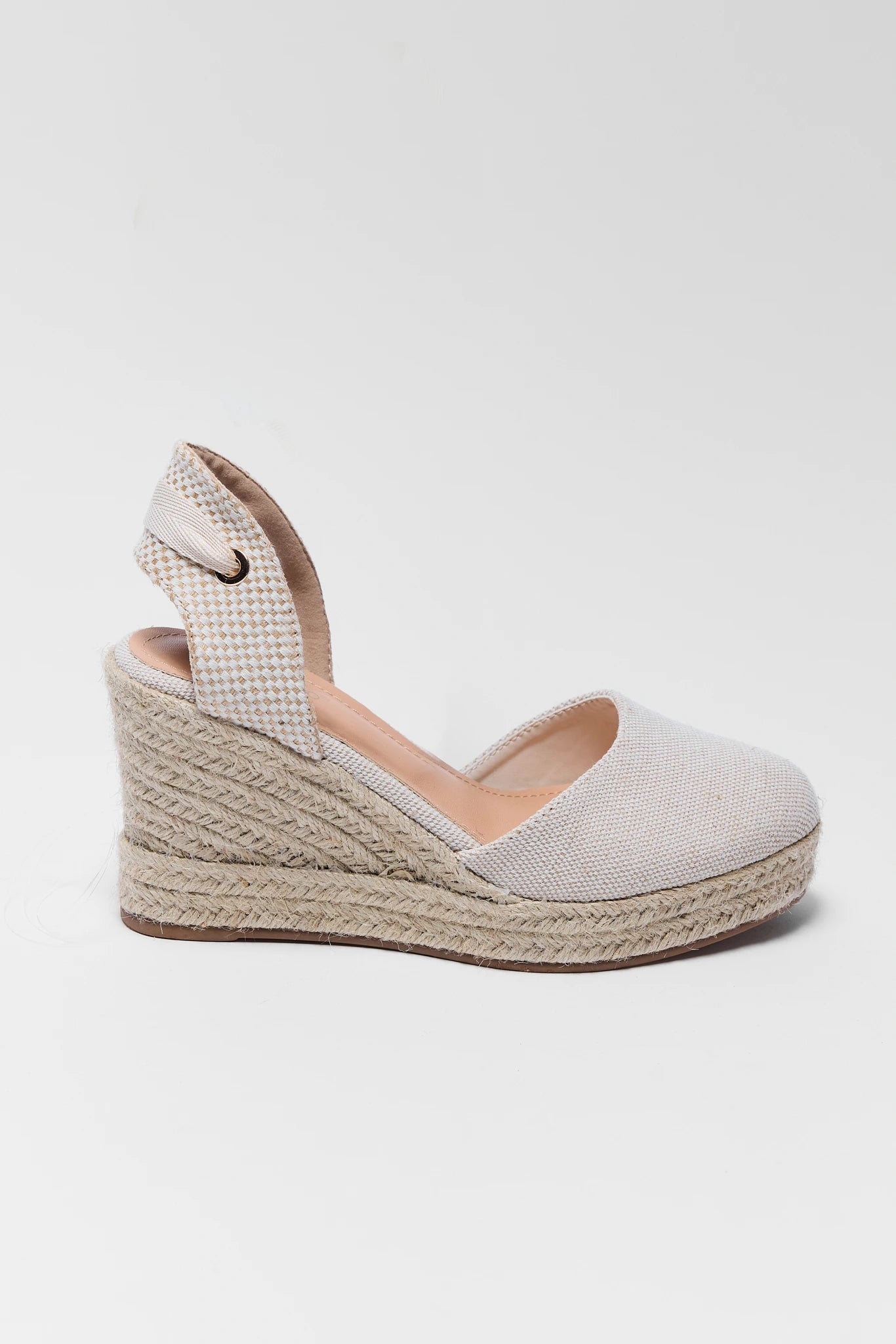 Beige wedge sandal with espadrille sole on a light gray background