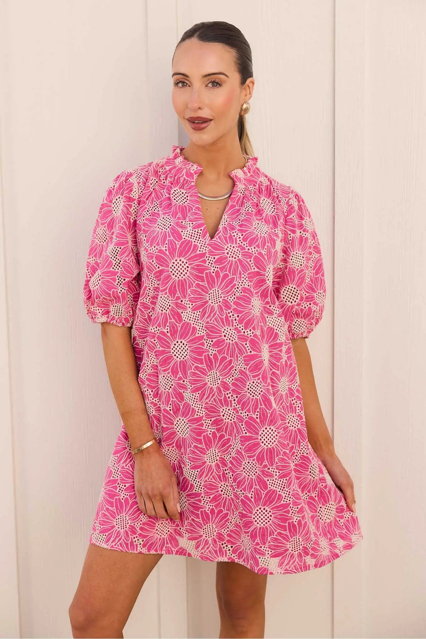 Bianca Pink Floral Eyelet Short Dress modeled, featuring a shift silhouette, eyelet embroidery, ruffled collar, V-neckline, puff sleeves, and above-knee hem.