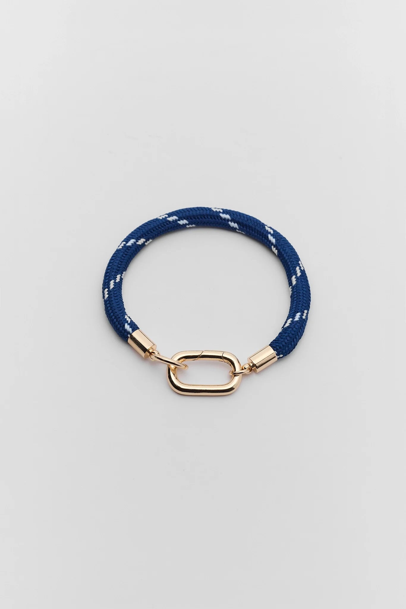 A navy blue braided rope bracelet with a gold-toned metal clasp, displayed on a light gray background.
