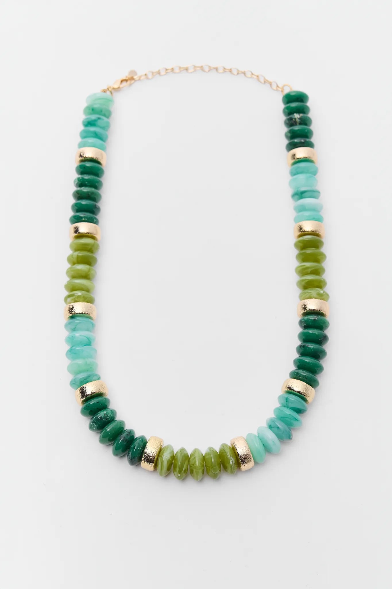 Necklace with green and gold beads on a white background