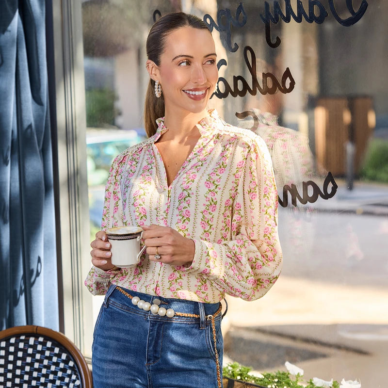 Woman holding a coffee cup in front of a store window