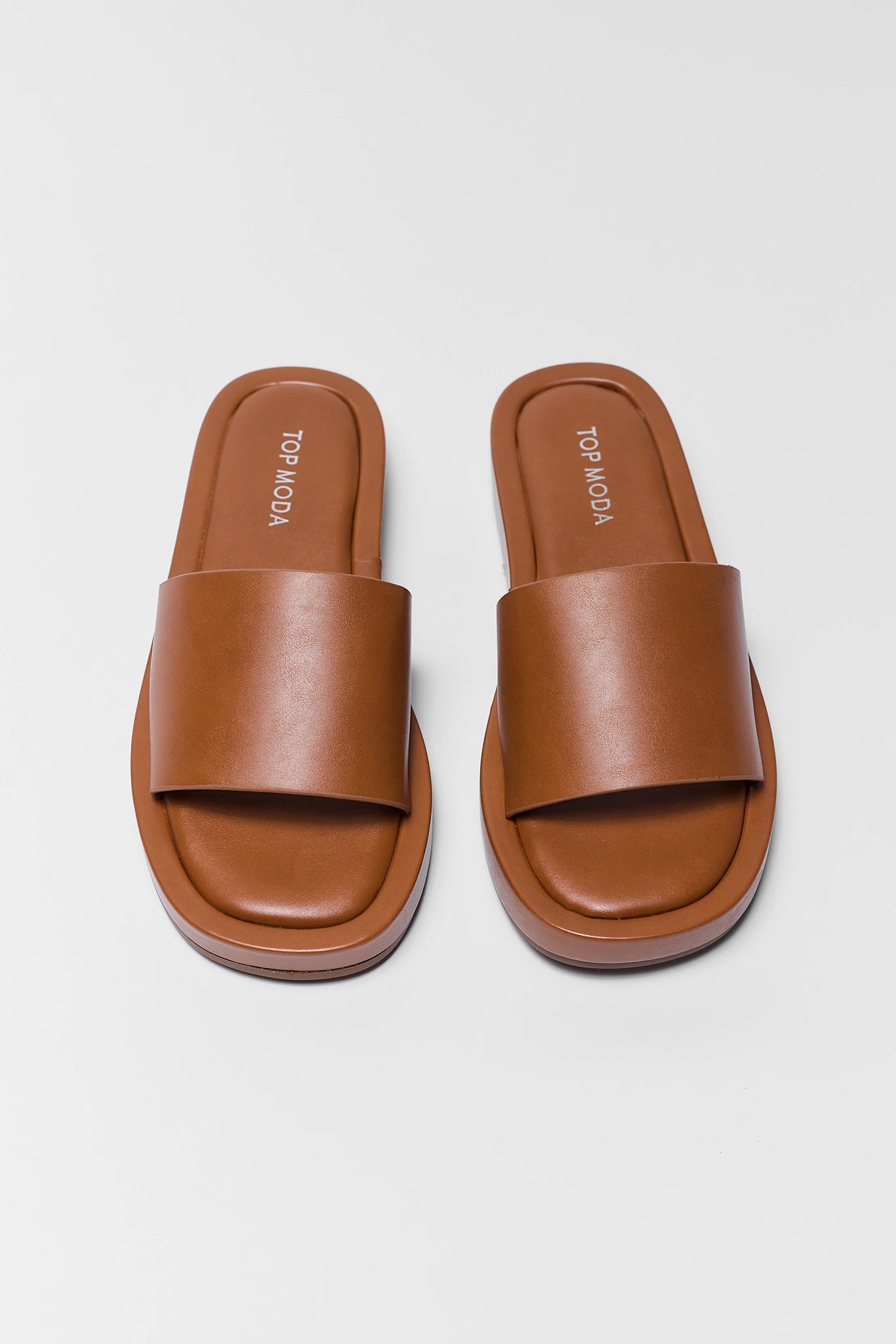 Pair of brown camel sandals on a white background