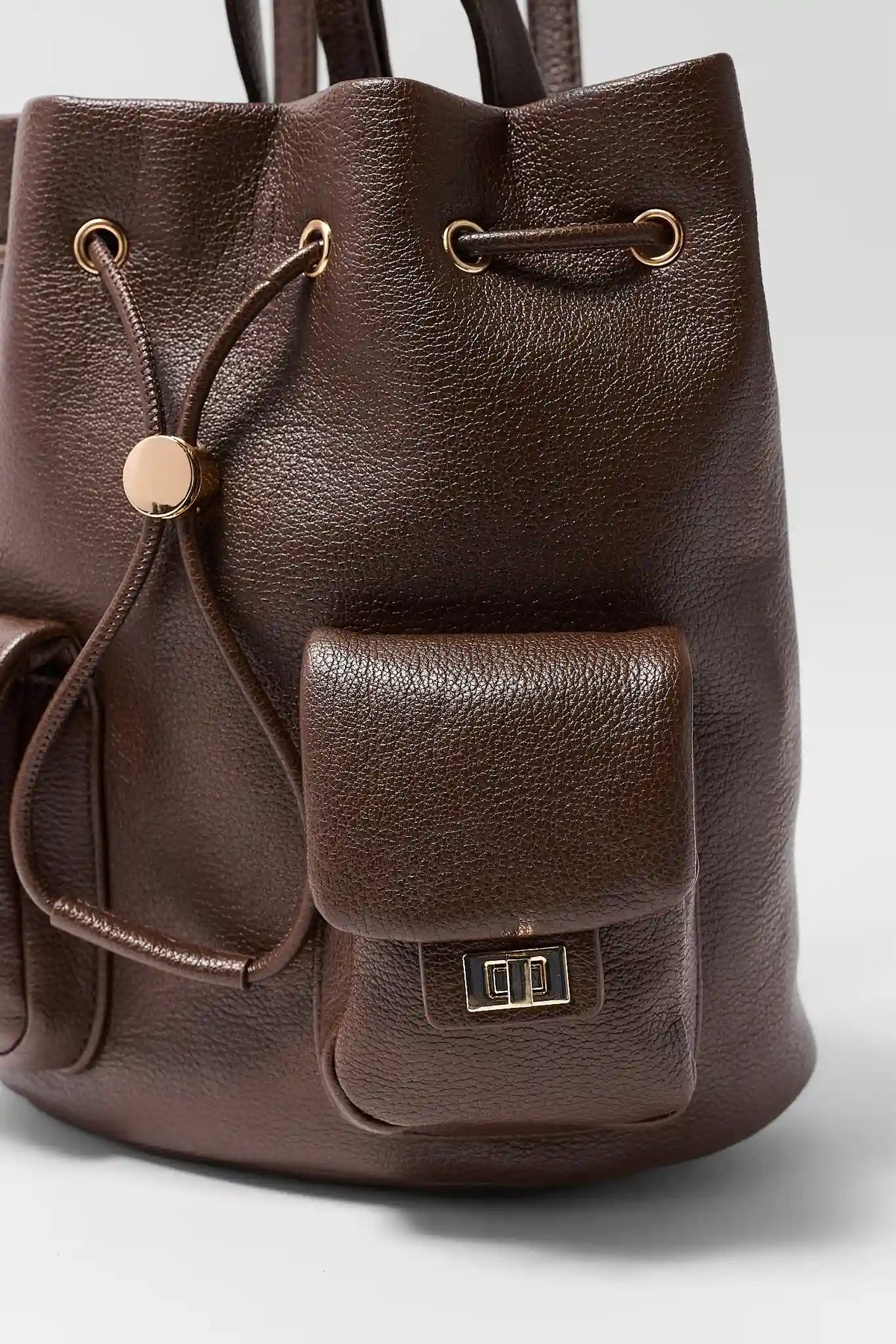 Brown Faux Leather Drawstring Backpack - Flap Pocket & Gold Hardware Close-Up | Avara