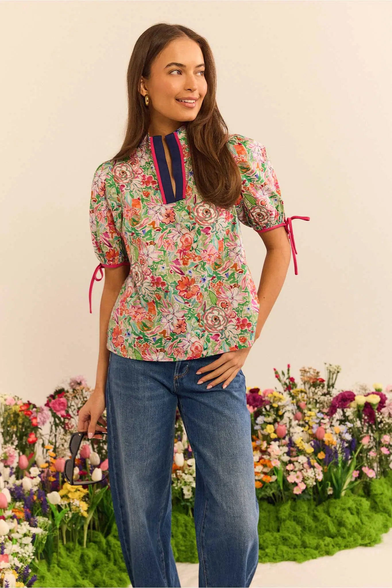 Woman wearing a floral blouse with a colorful background of flowers