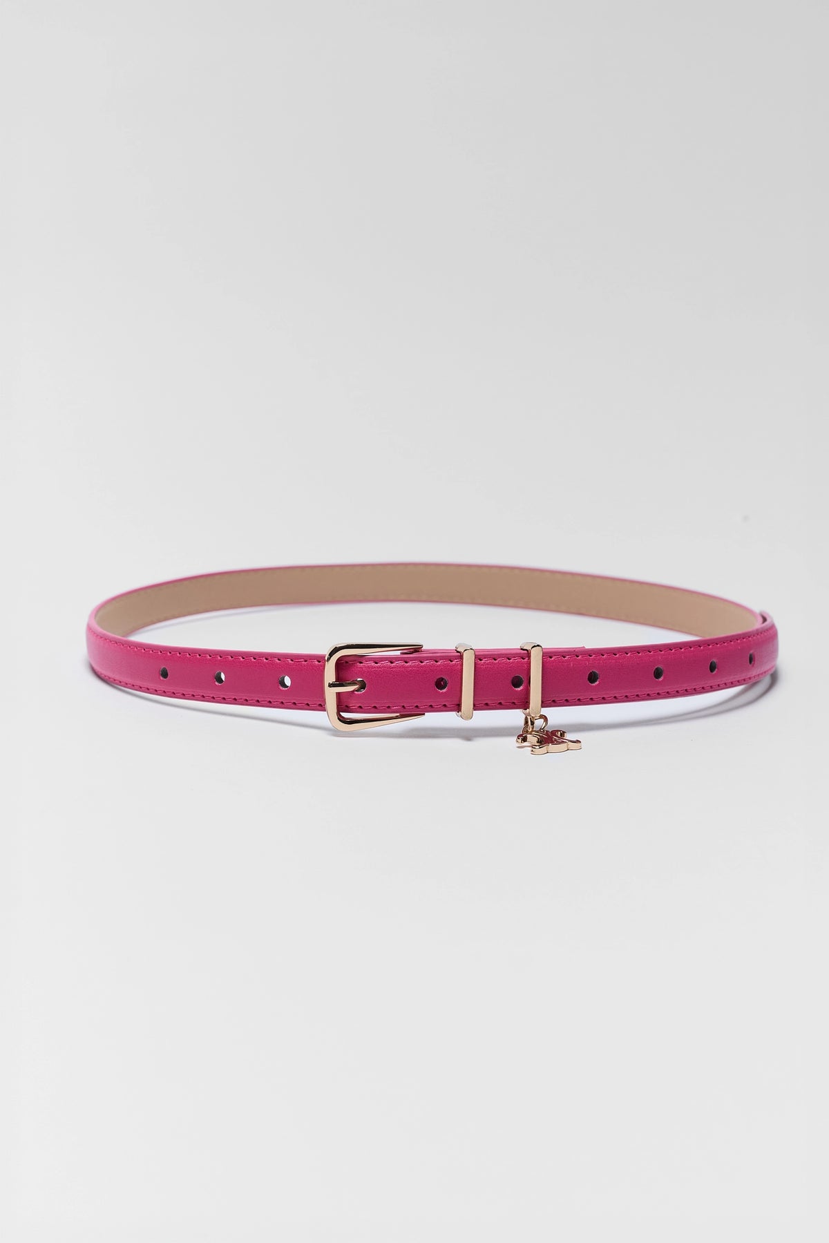 A slim magenta pink leather belt with a gold-tone buckle and a small gold-tone charm, displayed on a light gray background.