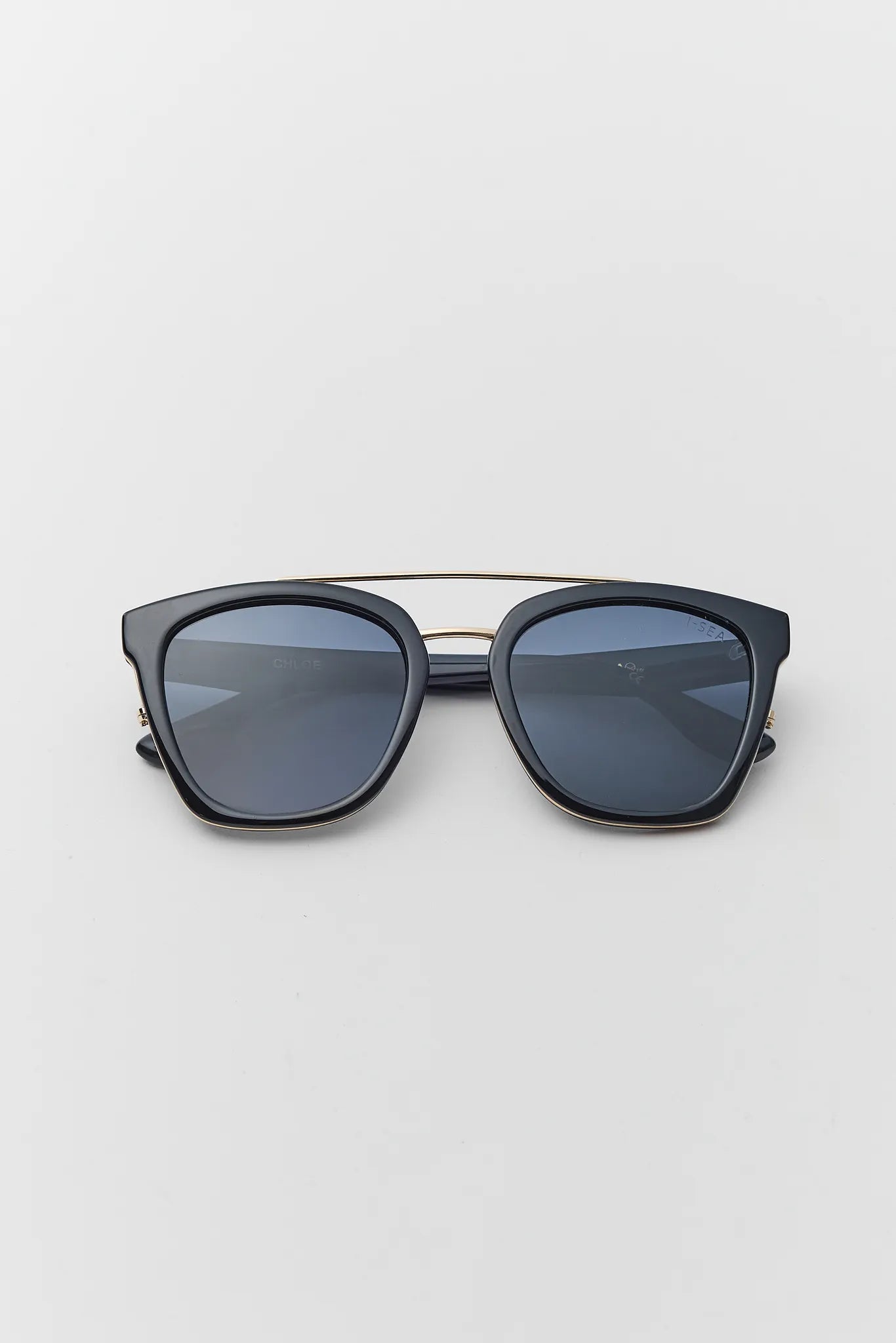 Black sunglasses with blue lenses on a light gray background