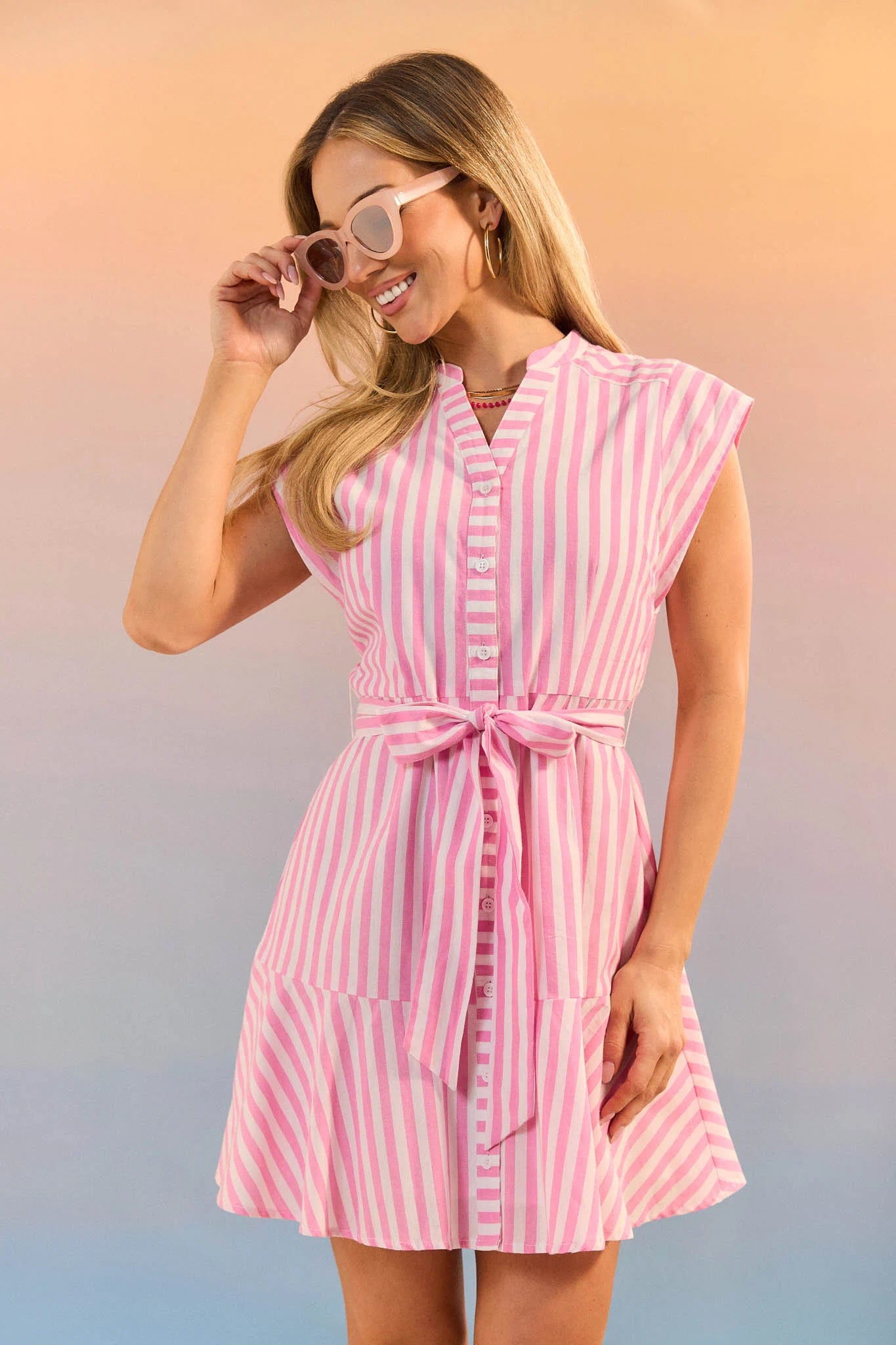 Woman wearing a pink and white striped dress against a gradient background