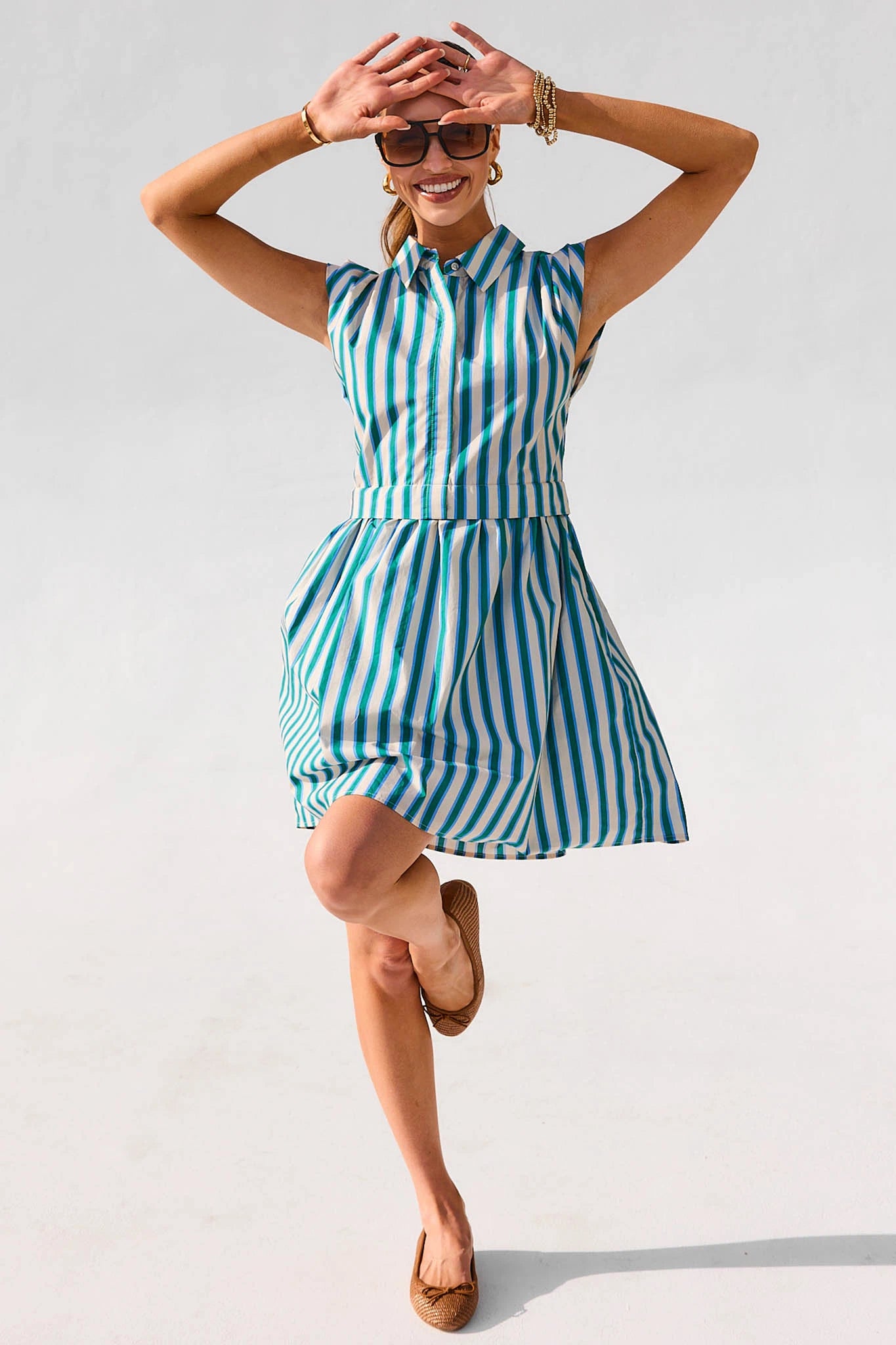 Woman wearing a blue and white striped dress on a plain background