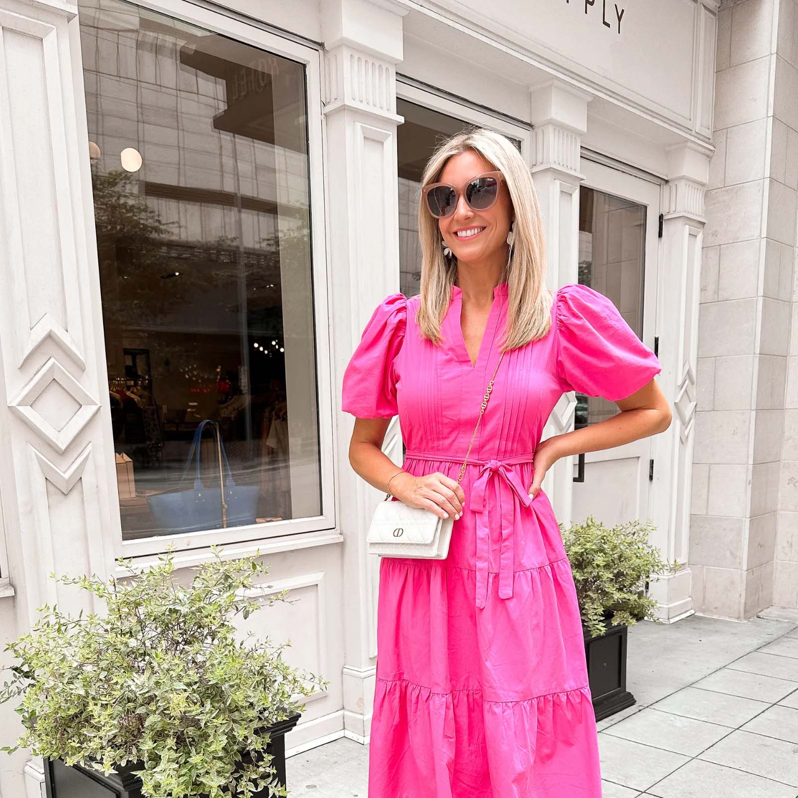 women wearing pink dress standing in front of store