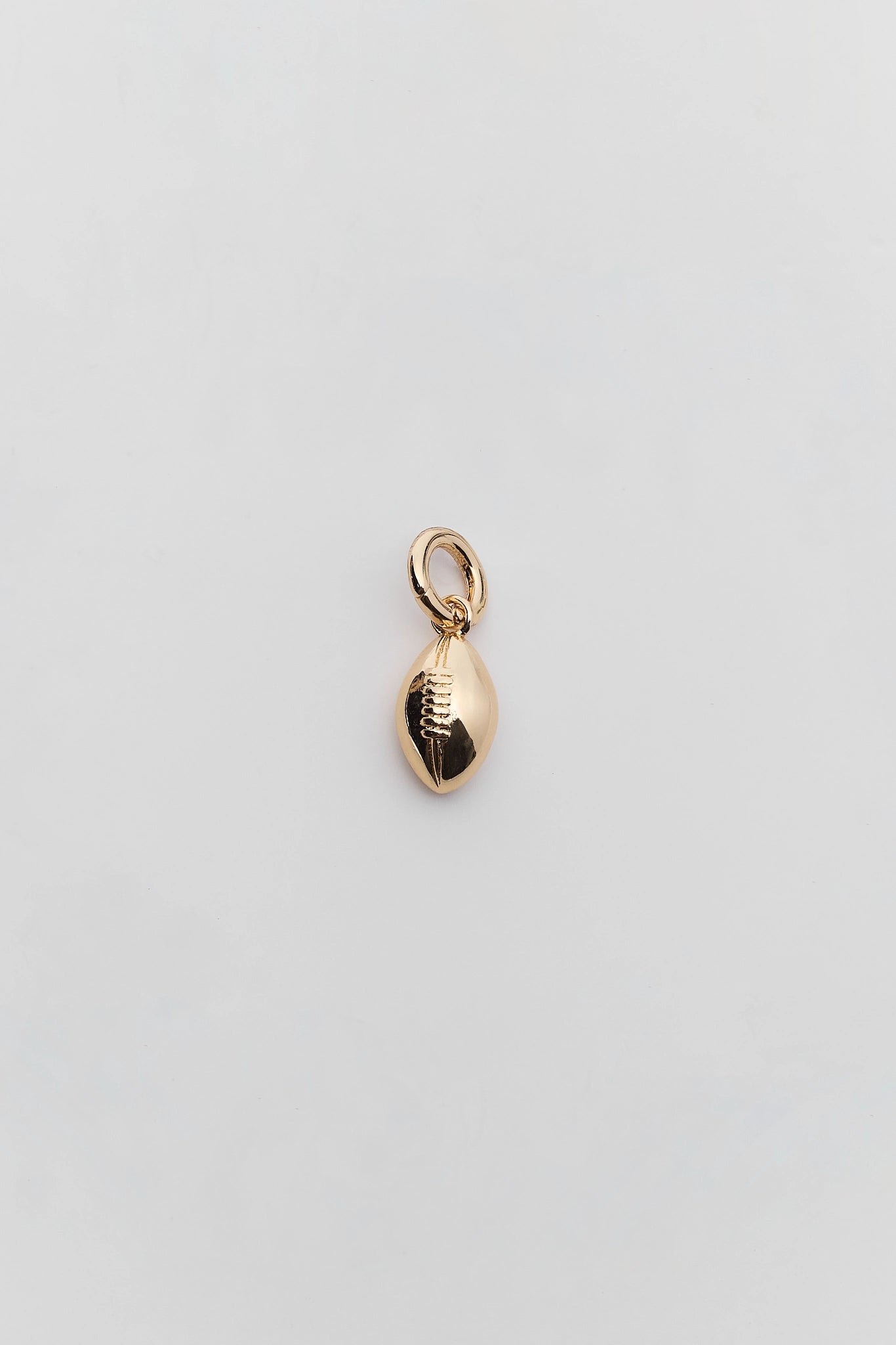 A small gold football-shaped charm with a hanging loop, centered on a plain light gray background.