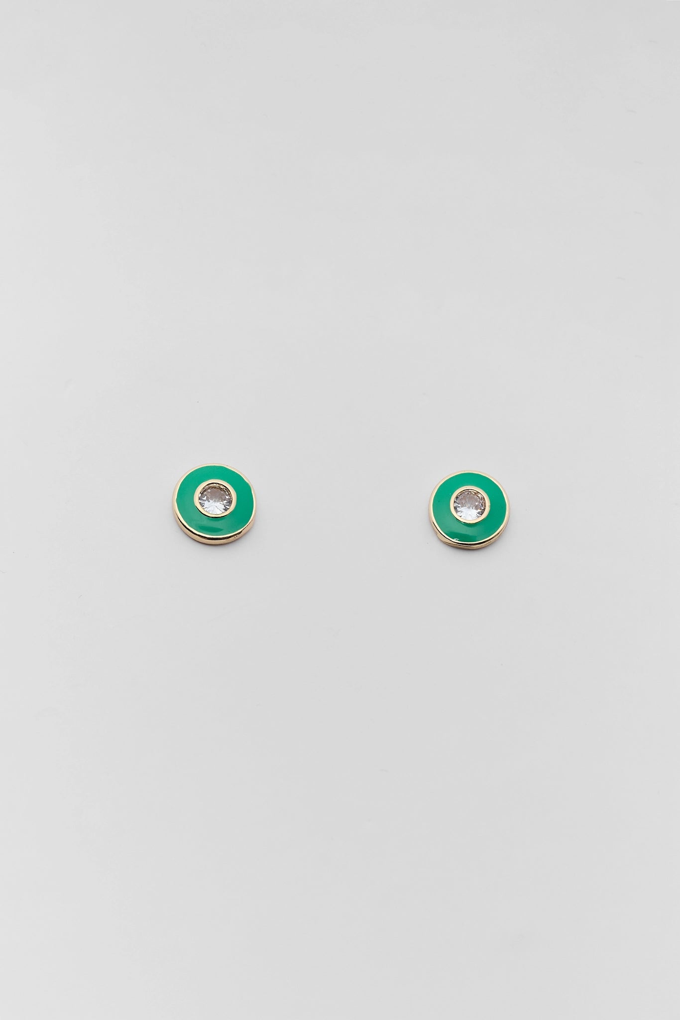 A pair of small round stud earrings with a bright green enamel outer ring and a silver-toned center, displayed on a light gray background.