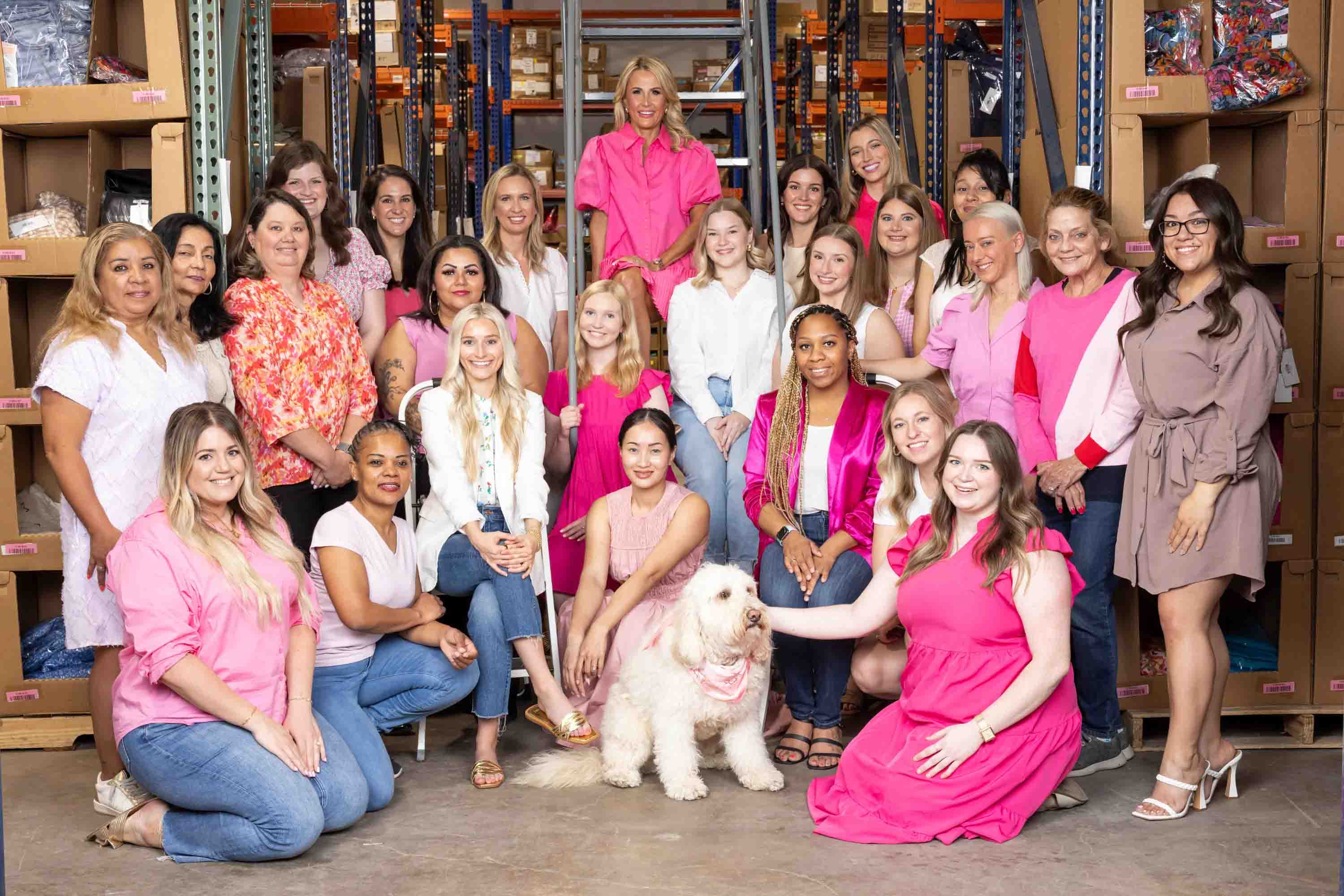 group of women standing in front of warehouse of clothing