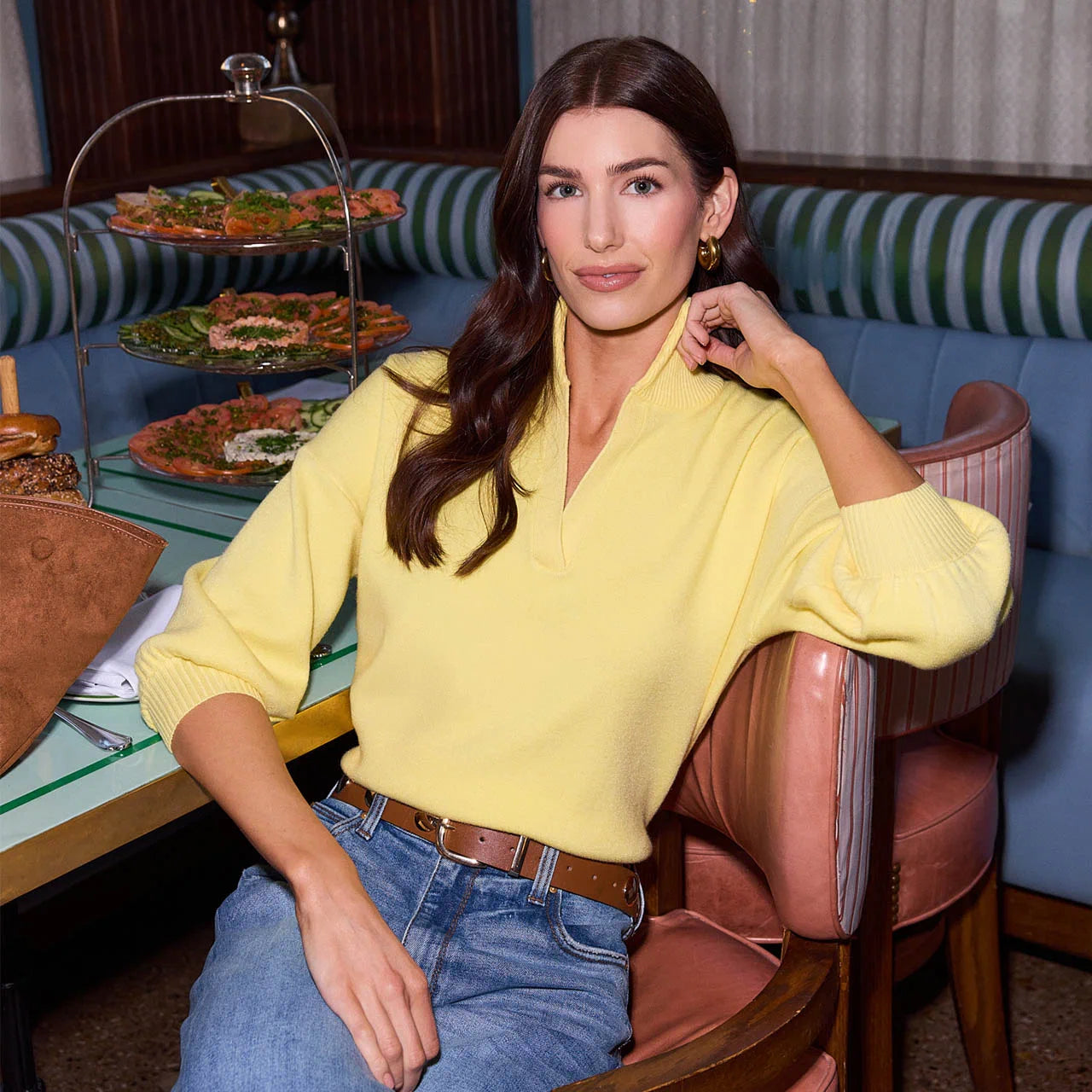 Woman in a yellow sweater sitting in a restaurant.