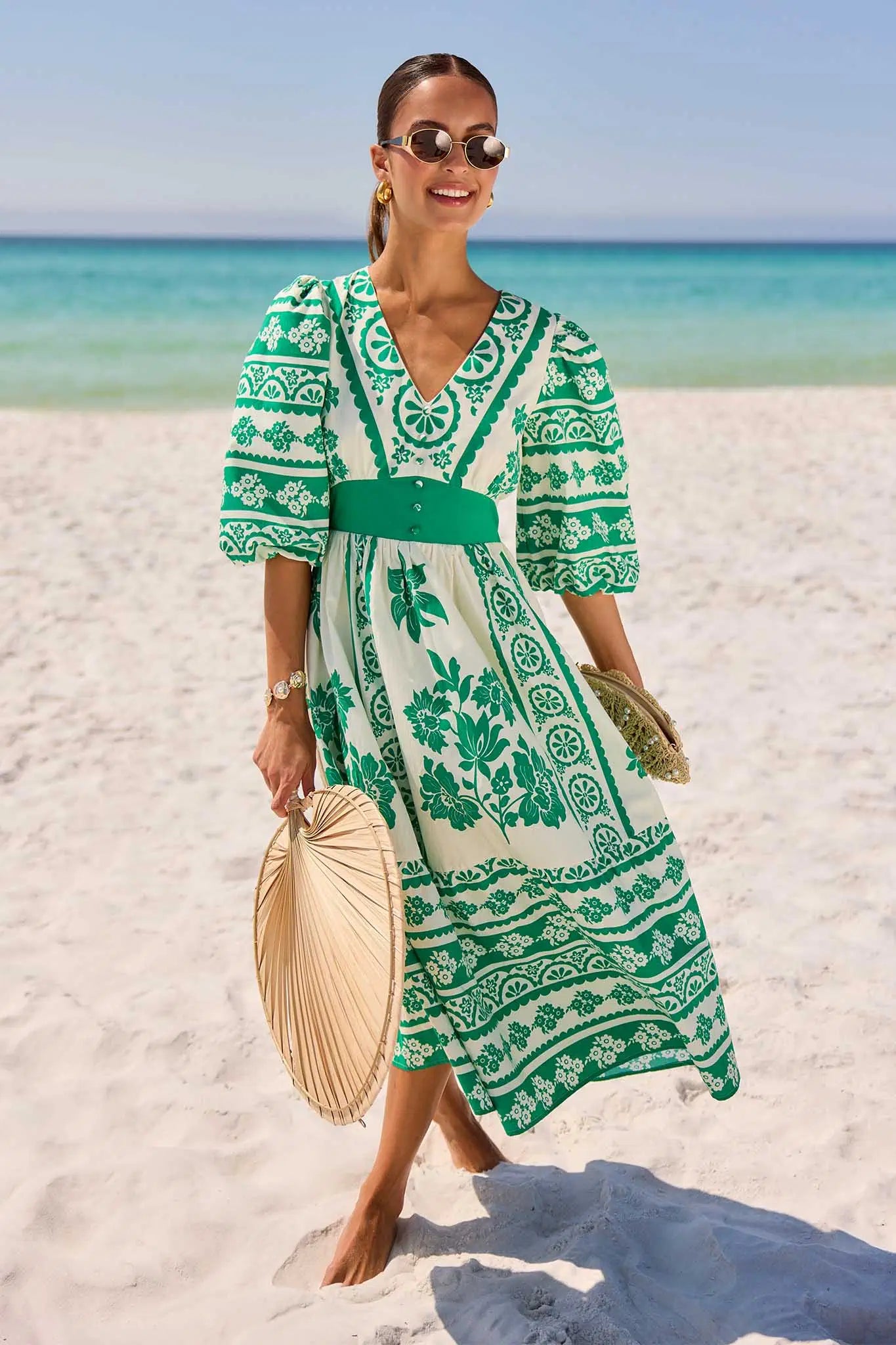 Woman in a green and white patterned hadley dress on a beach