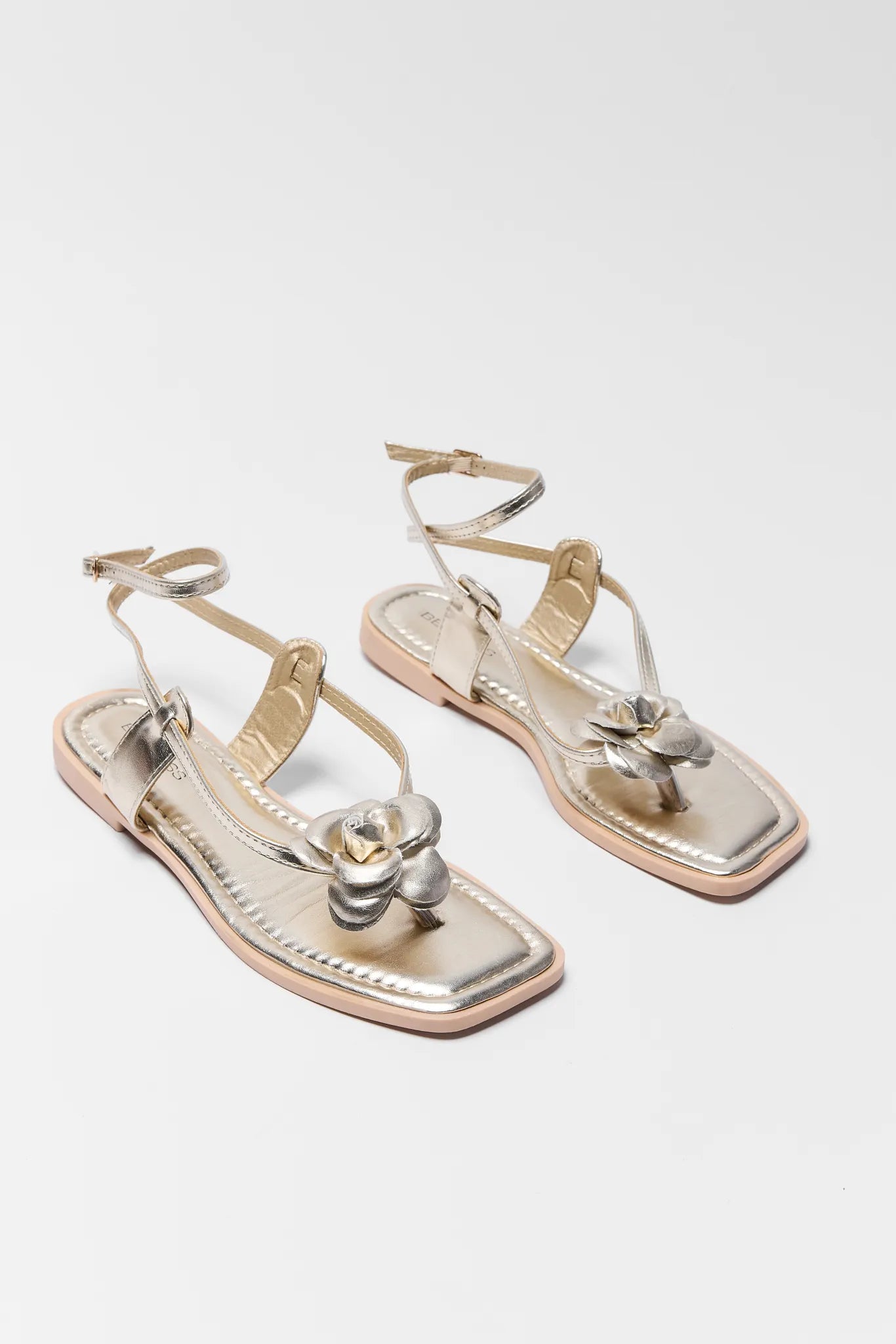 Pair of Harper Gold Strappy Flower Sandals on a white background