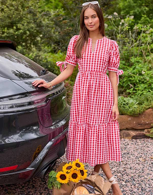 woman wearing red gingham dress with sunflowers outdoors