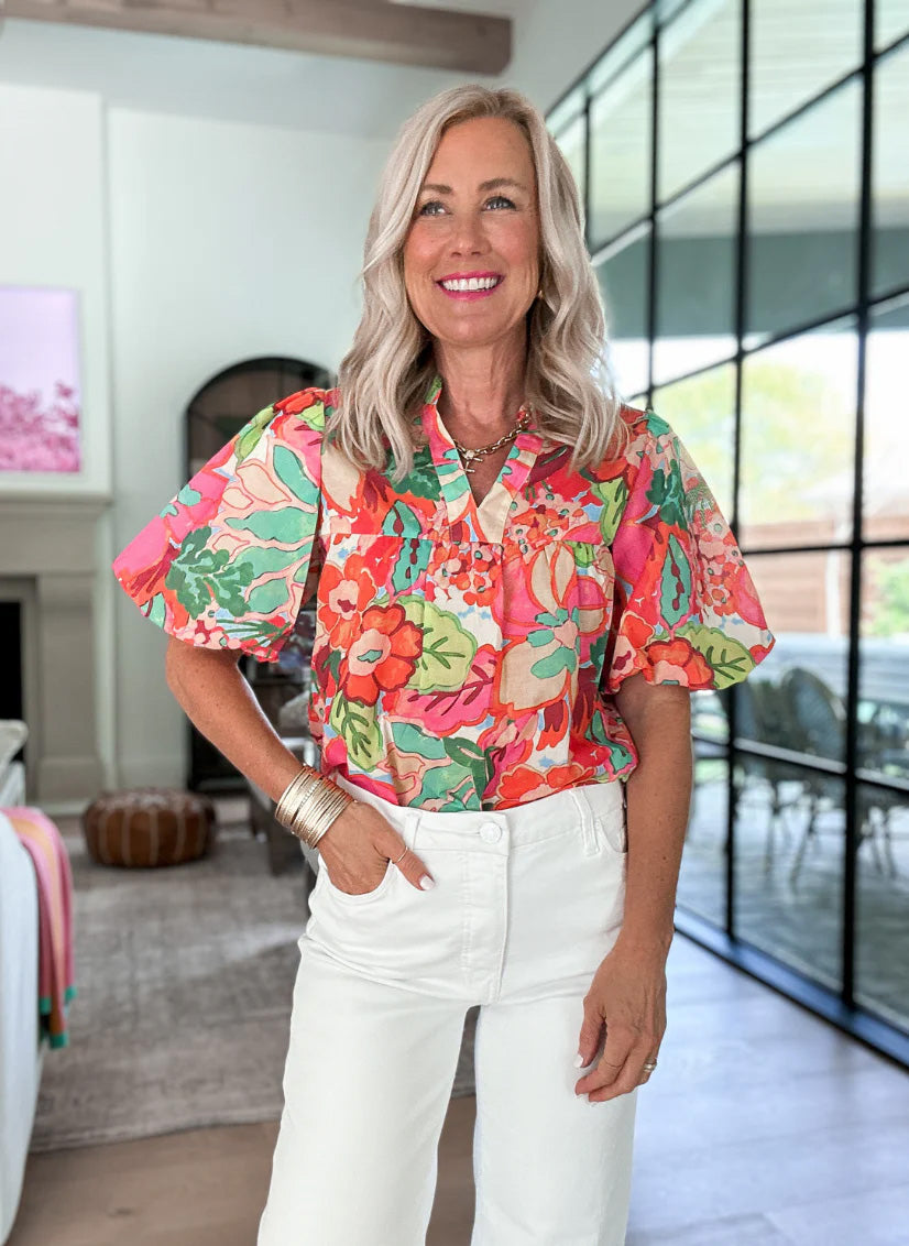 Women wearing floral top and white jeans with blurred background