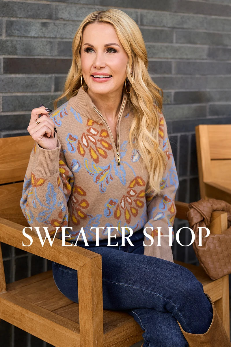 Woman sitting on a wooden bench wearing a patterned sweater with 'SWEATER SHOP' text overlay.
