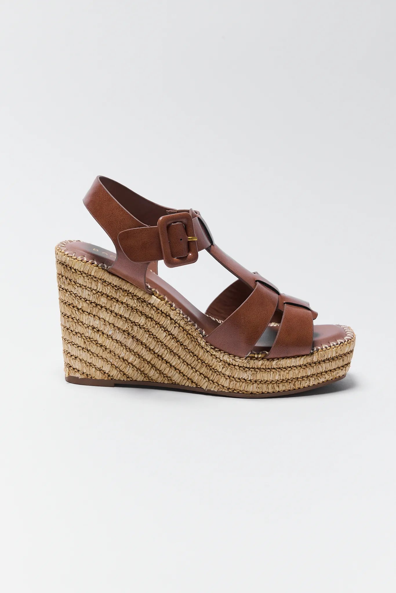 Brown wedge sandal with espadrille sole on a light gray background