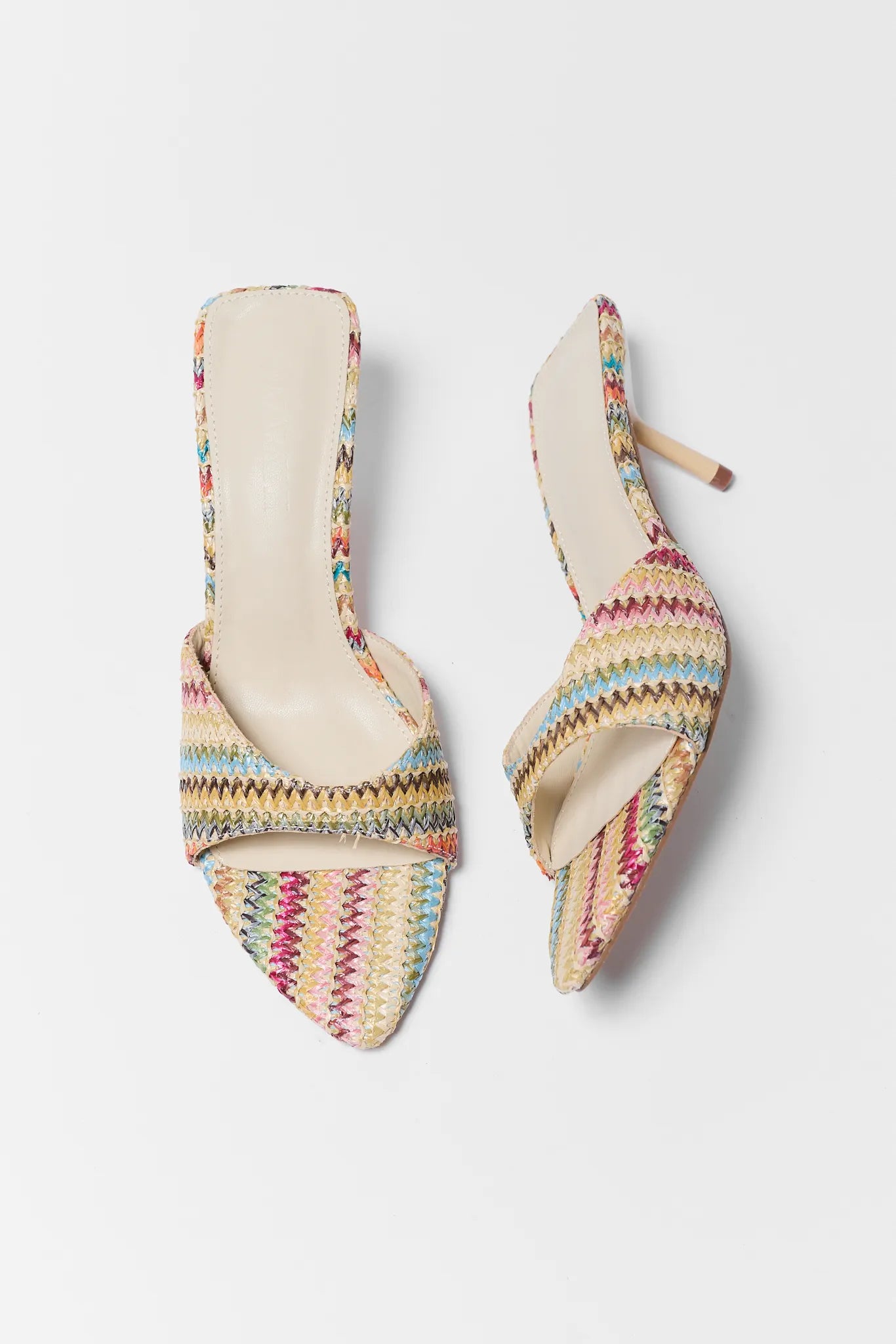 Pair of colorful striped high-heeled shoes on a light gray background