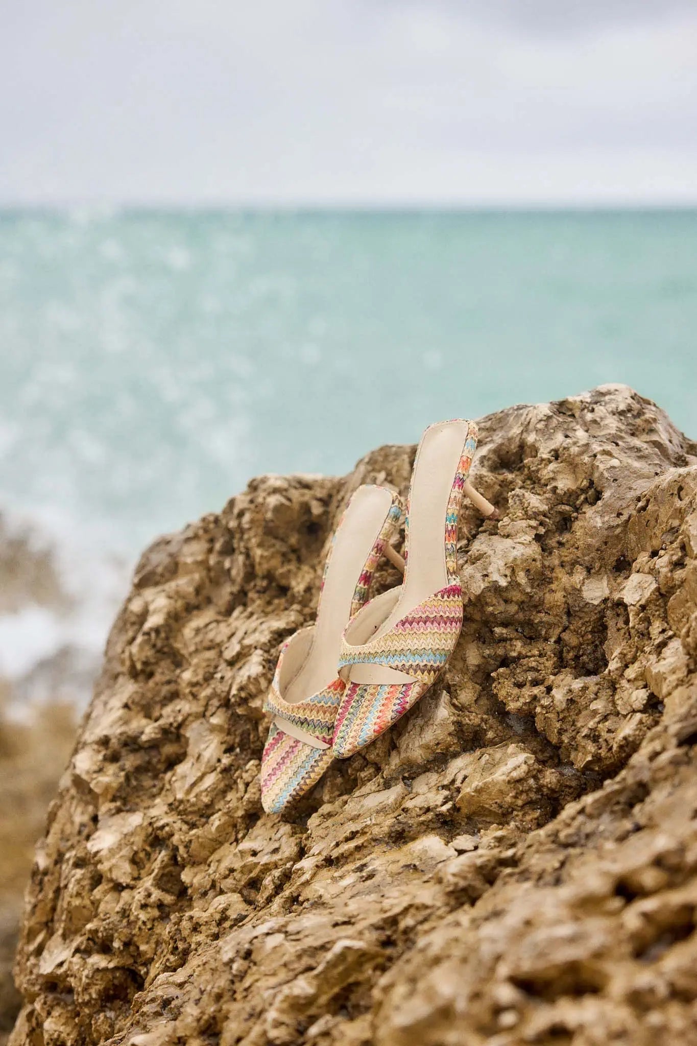 Colorful sandal on a rock with ocean in the background