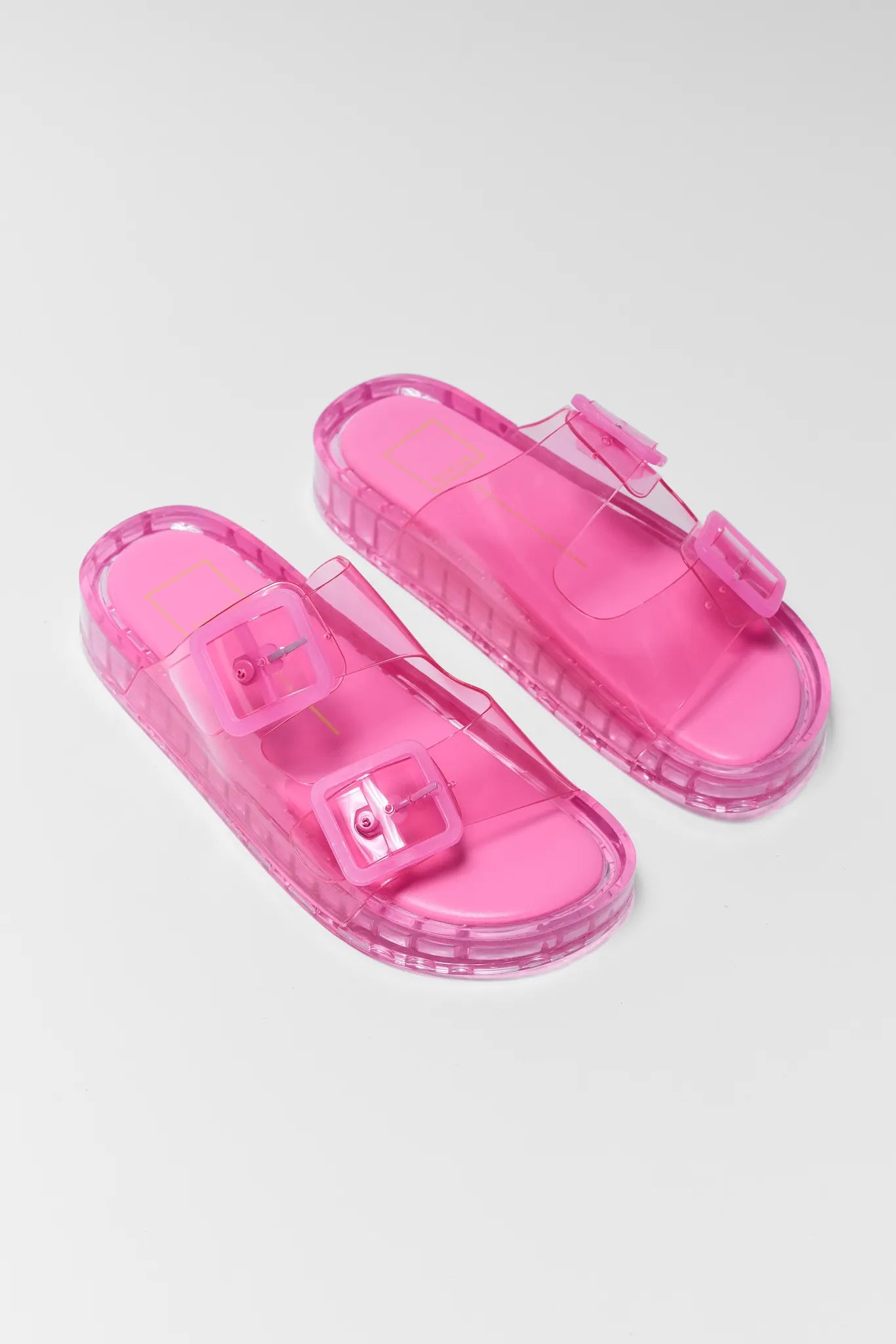 Pink transparent sandals on a light gray background