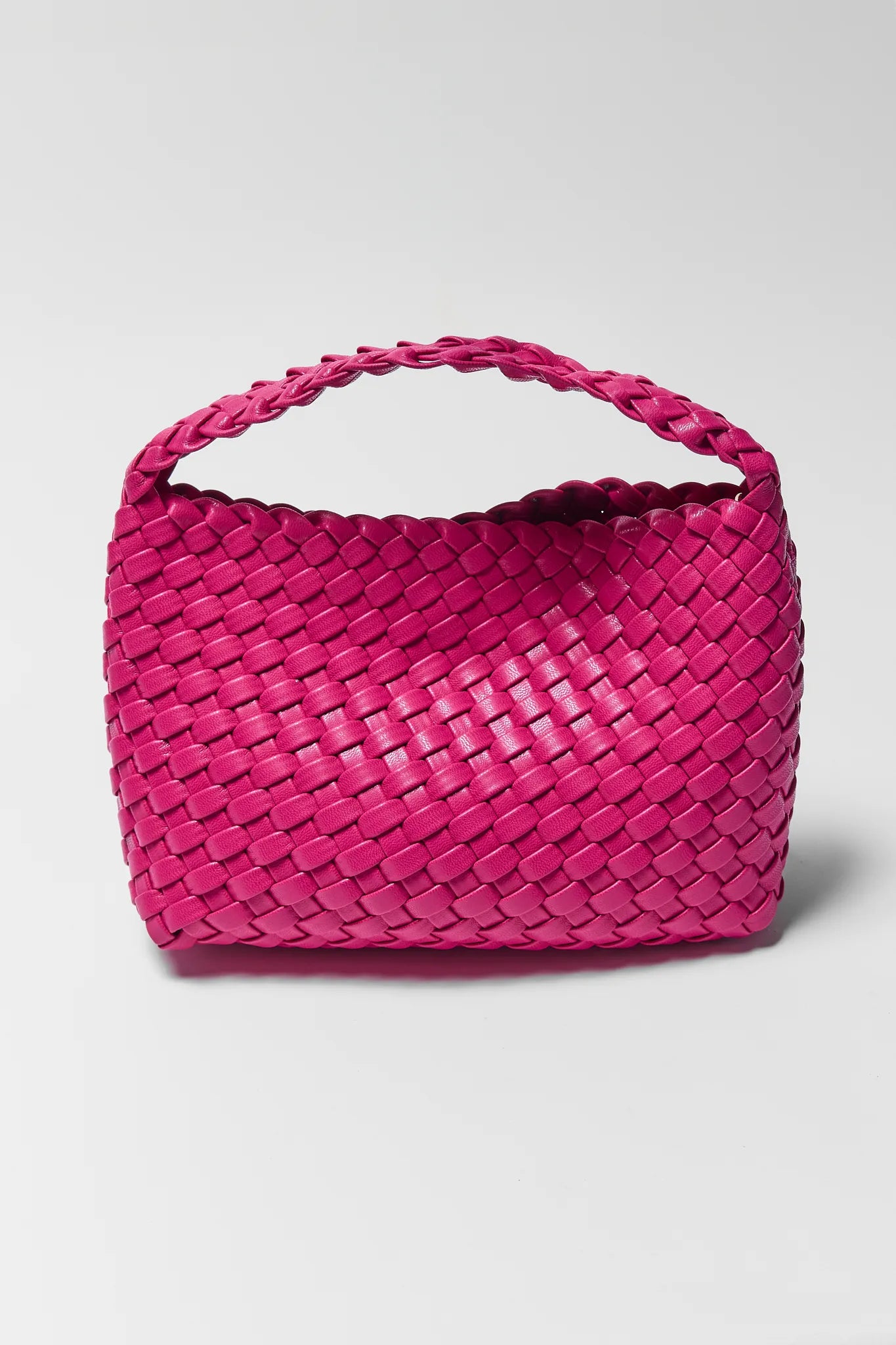 Pink woven handbag on a light gray background
