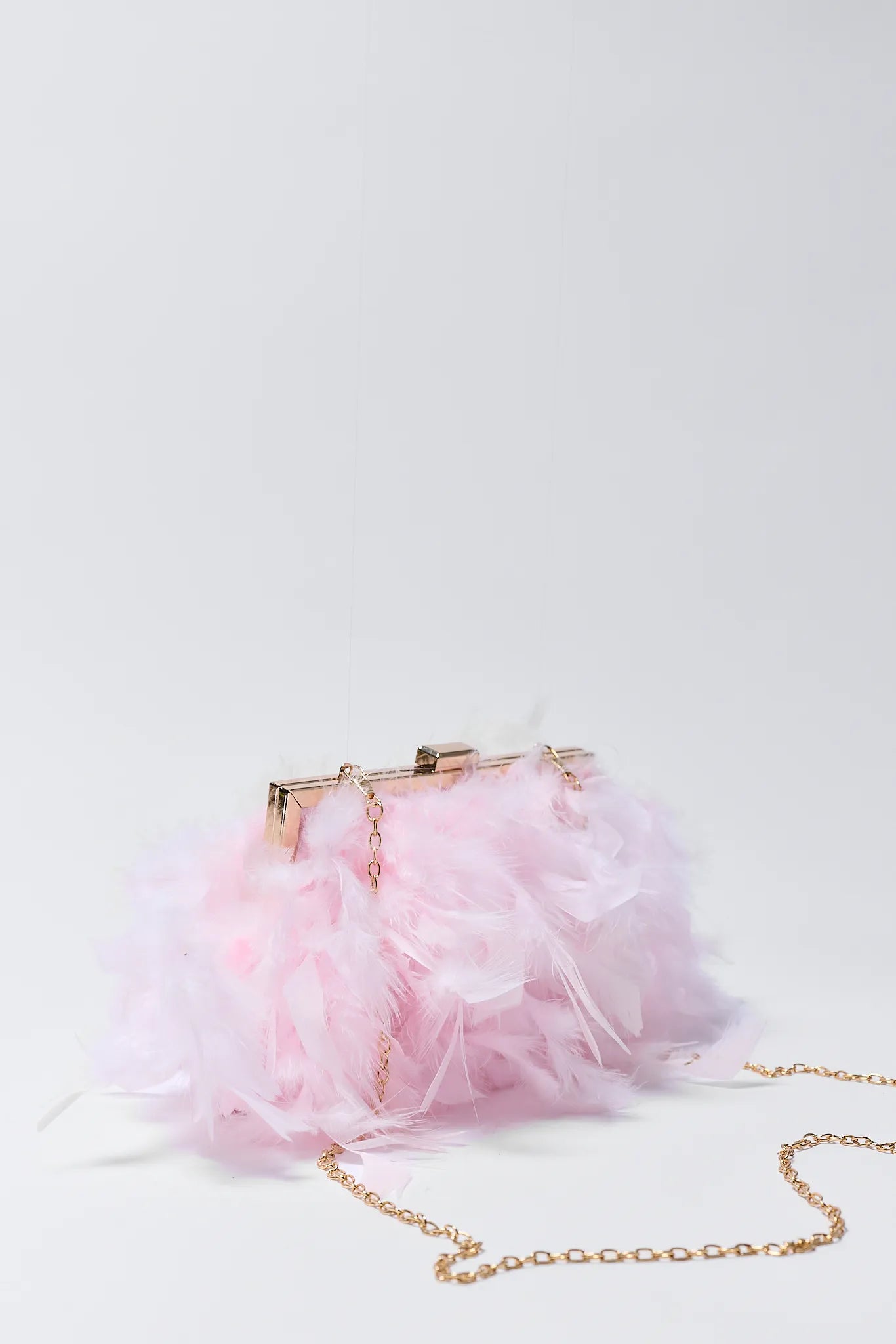 Pink handbag with gold chain on a light gray background