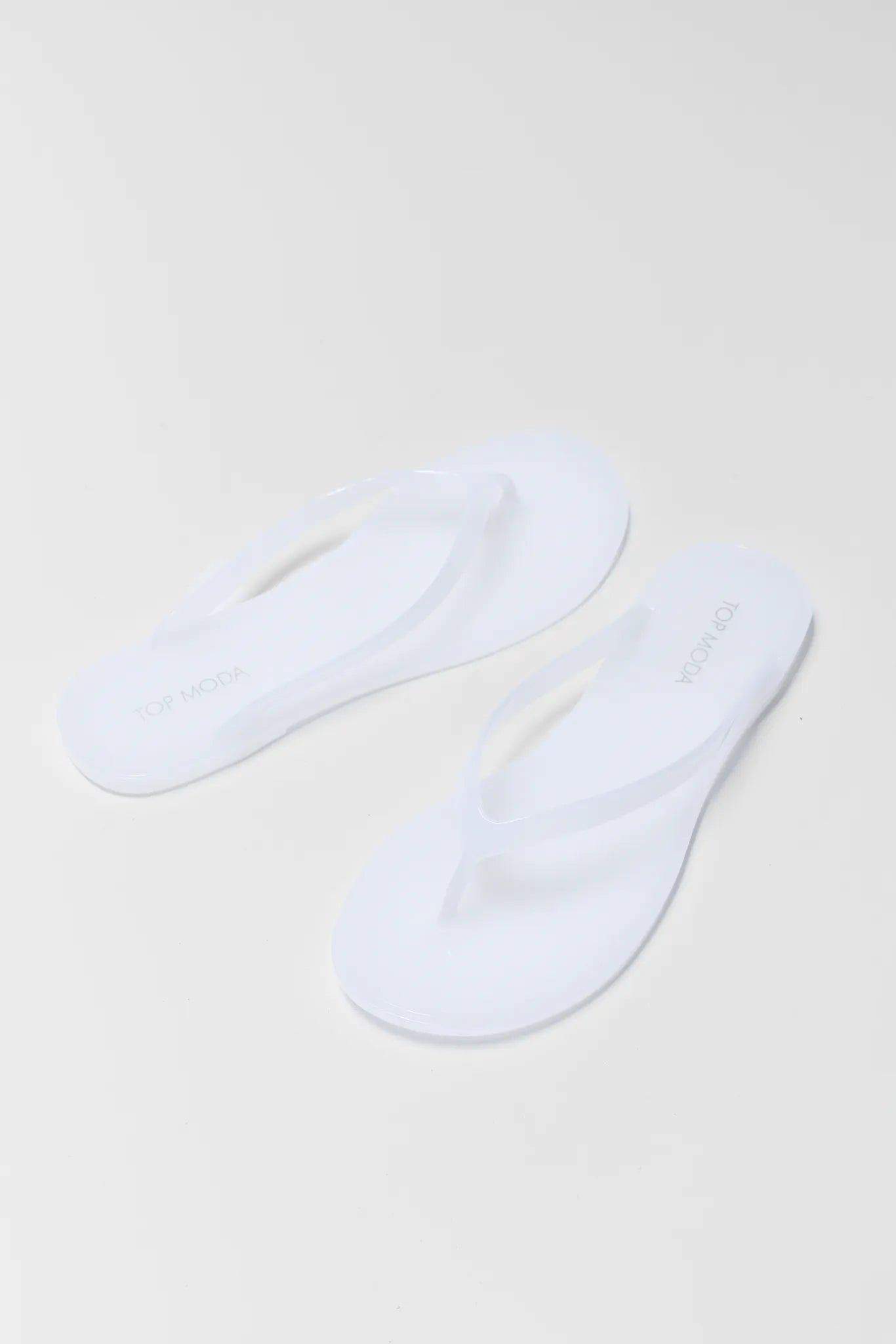 Two white ankle socks on a light beige background