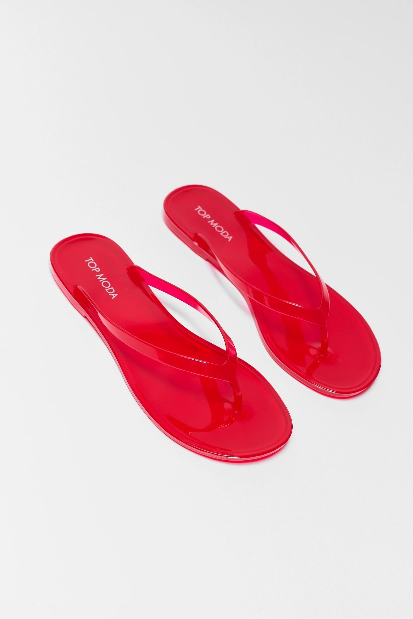 two Red flip-flops with branding on a white background