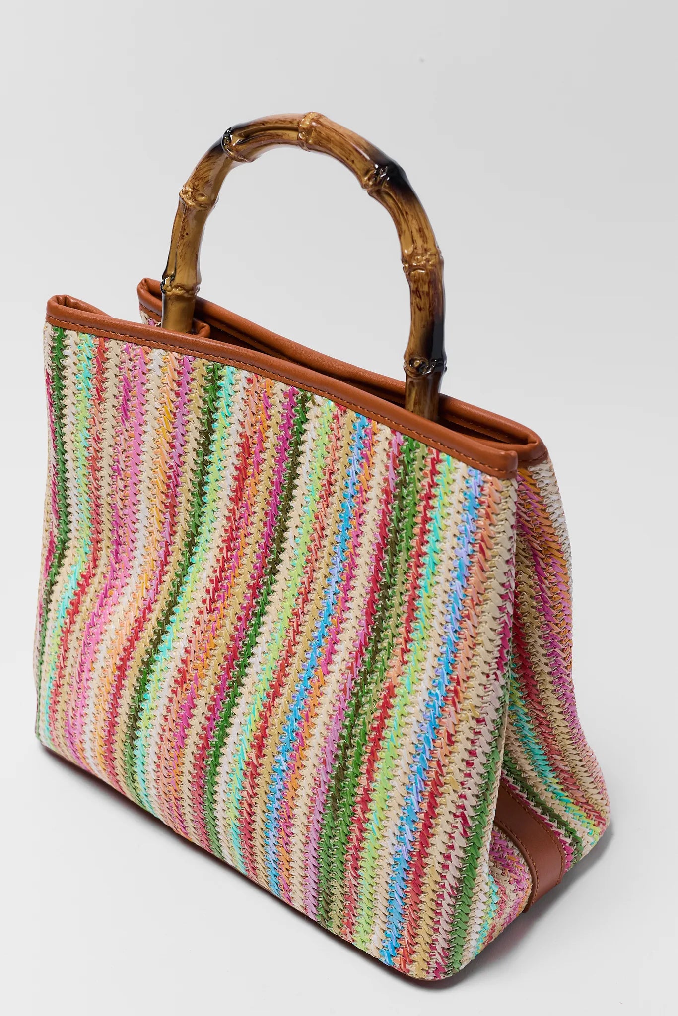 Colorful striped handbag with a brown handle on a light gray background