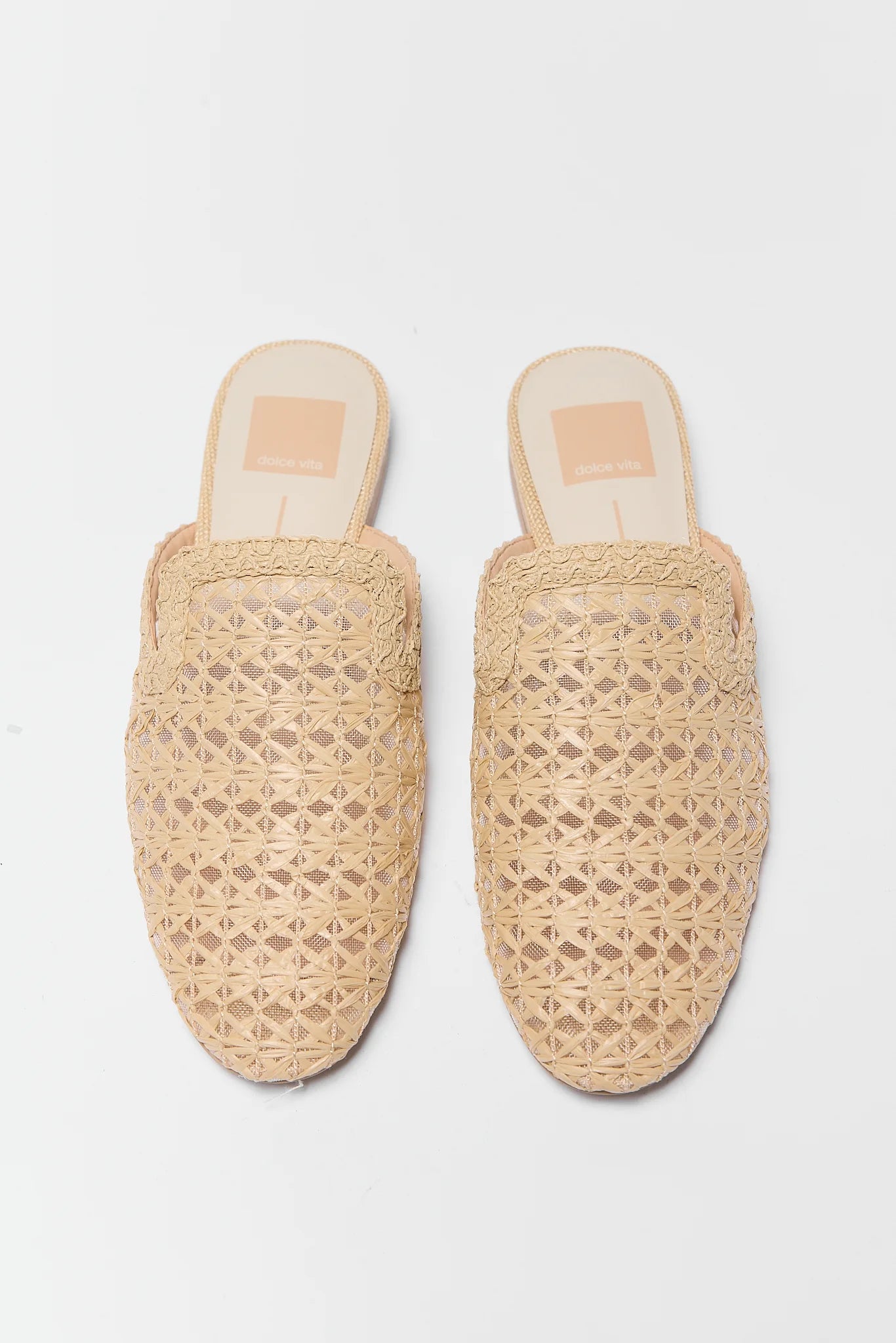 Pair of woven slide on shoes on a light gray background