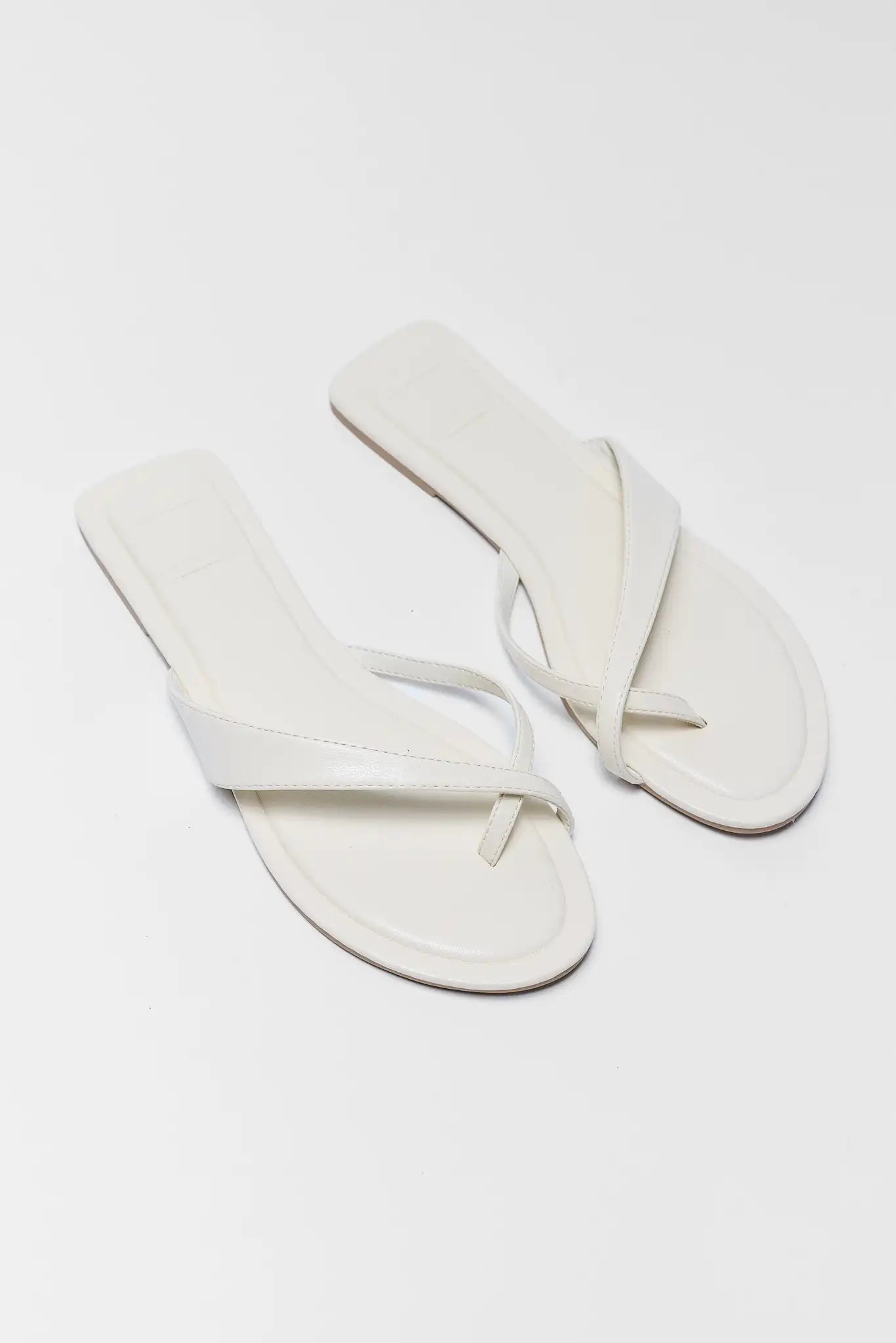 Pair of white sandals on a light gray background