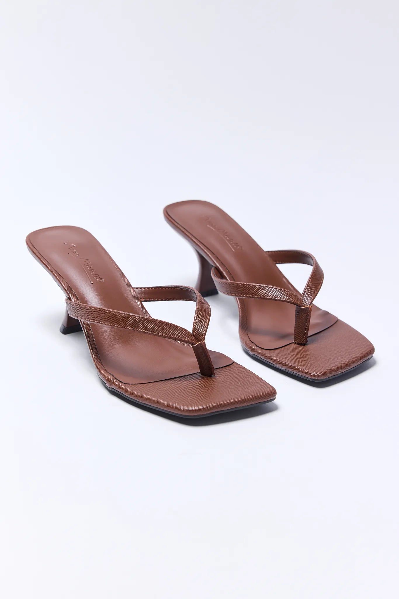 Pair of brown high-heeled Lindy Heels on a white background
