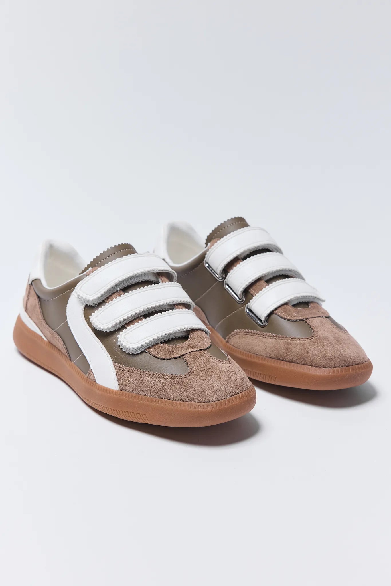 Pair of brown and beige Lizzie Sneakers with white velcro straps on a light gray background