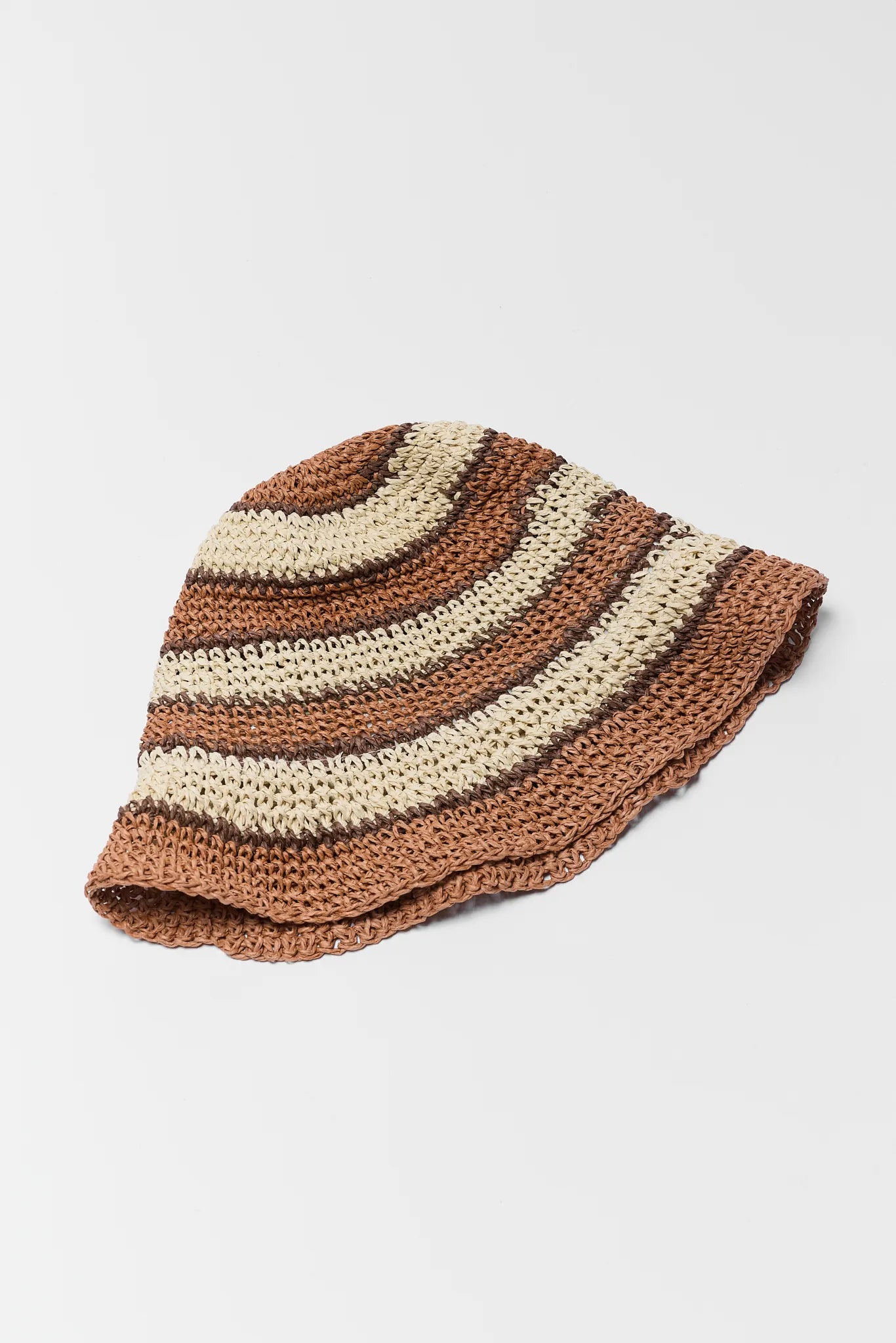 Striped knitted bucket hat in brown and beige on a light gray background