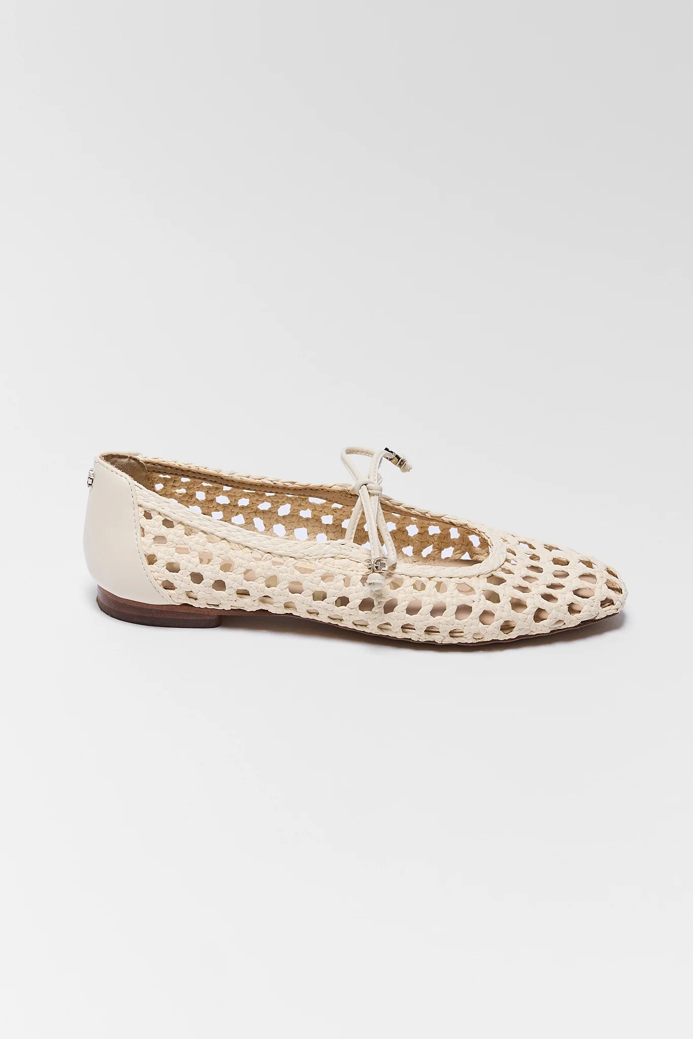 Beige flat shoe with cut-out design on a white background