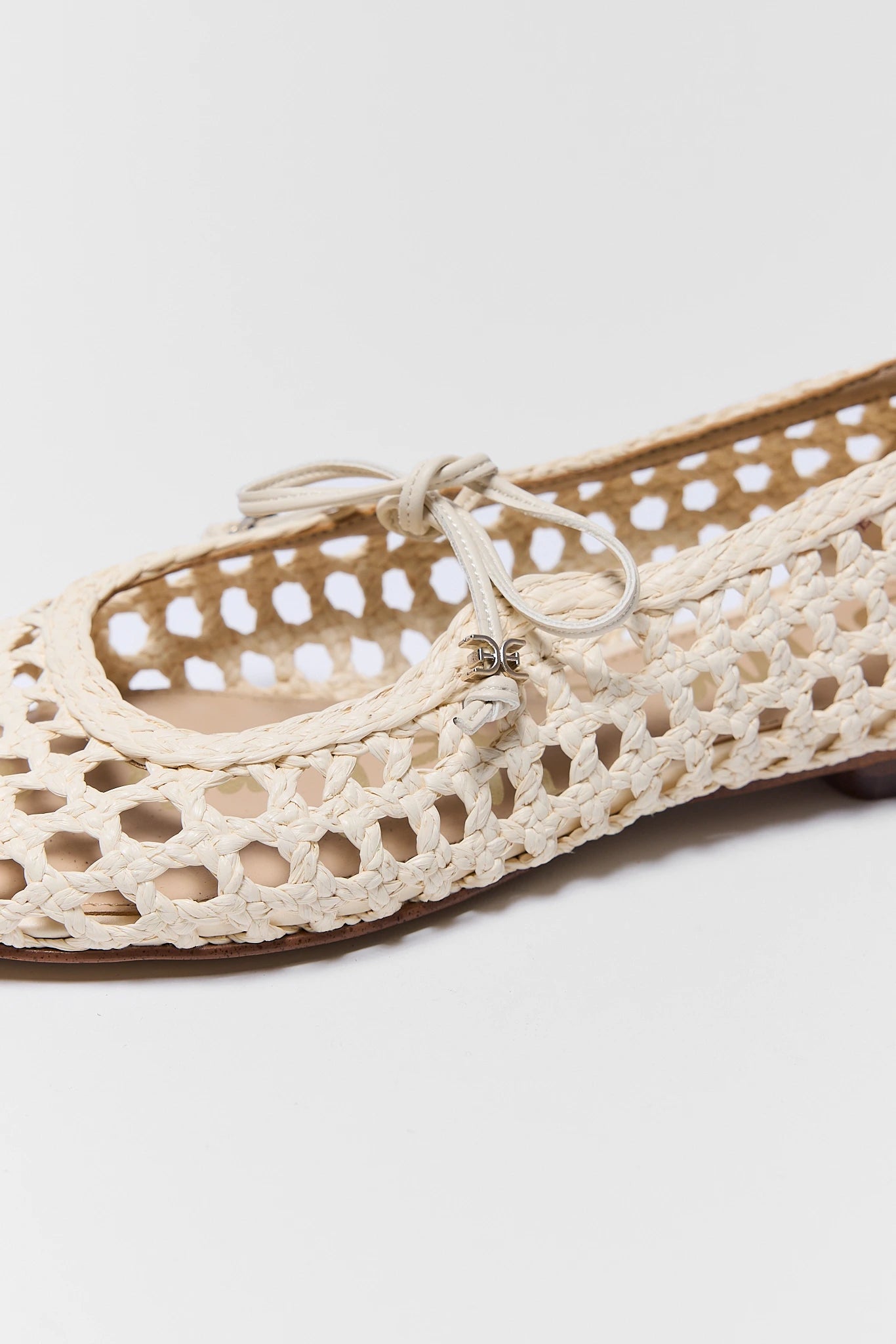 Beige woven flat shoe on a light gray background