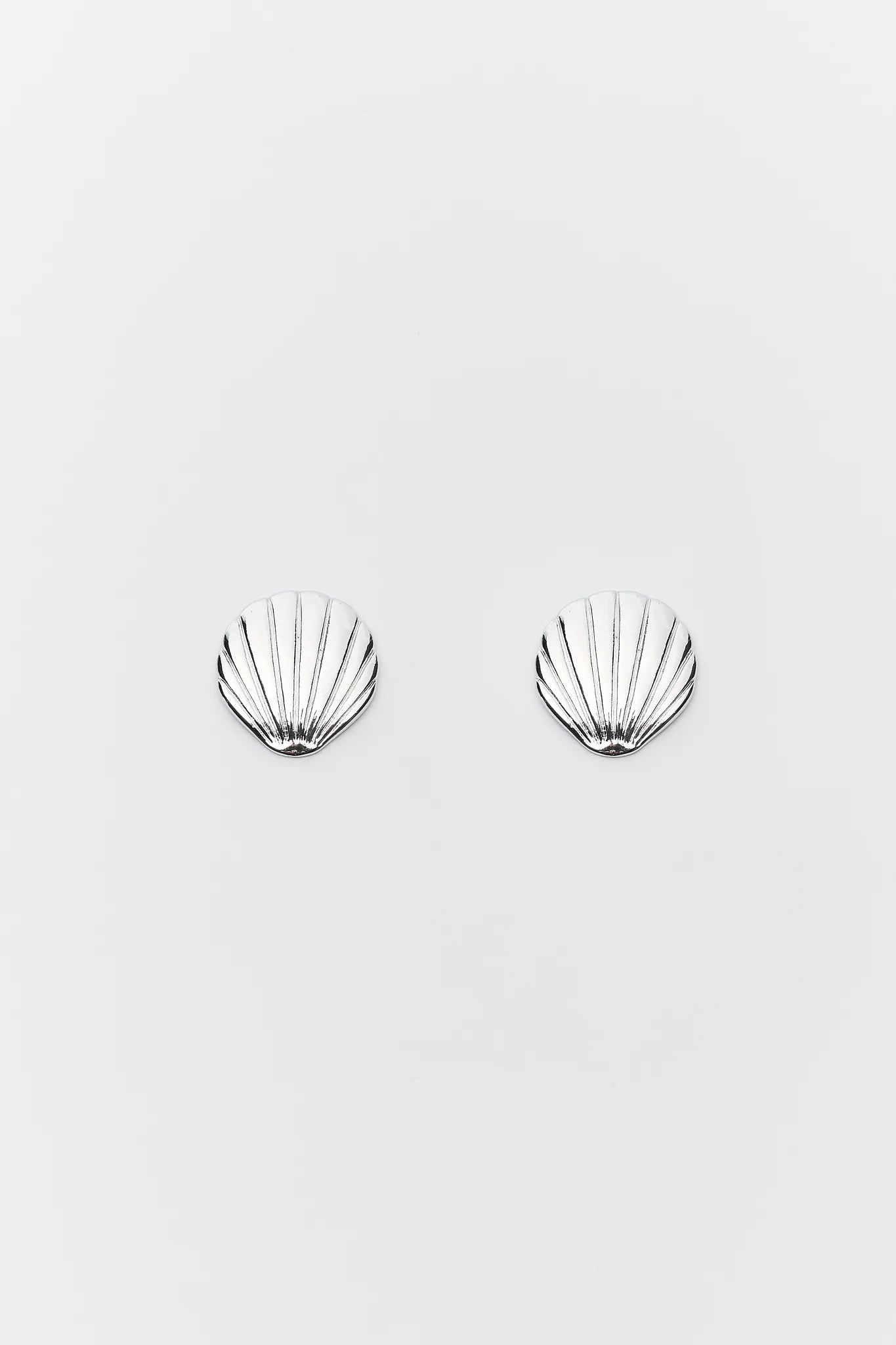 Shell-shaped earrings on a light gray background