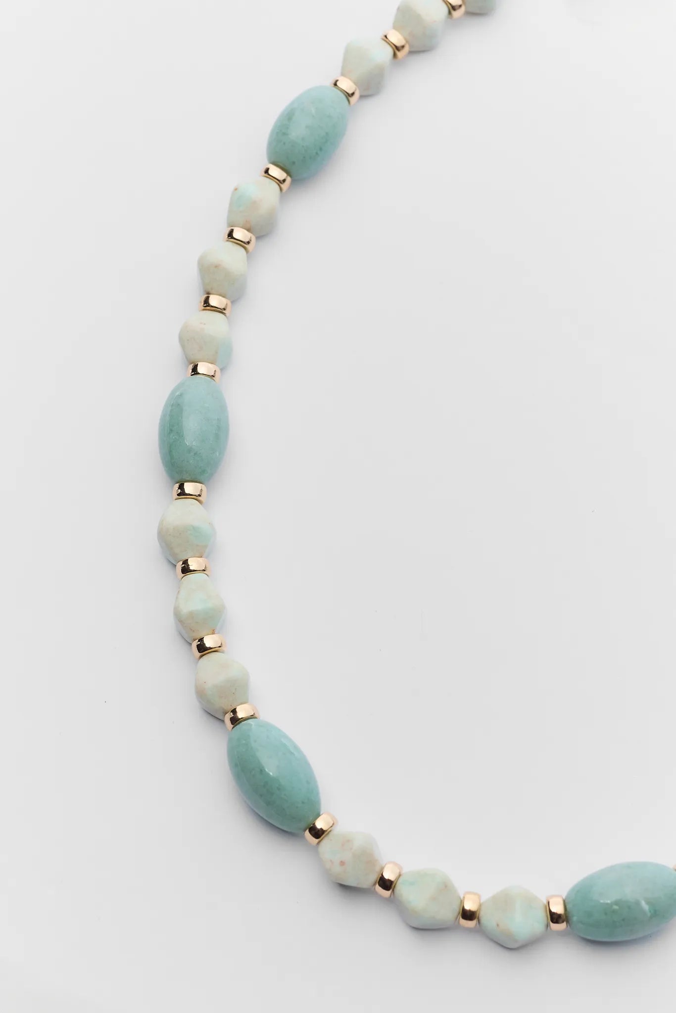Necklace with light blue beads and gold accents on a white background