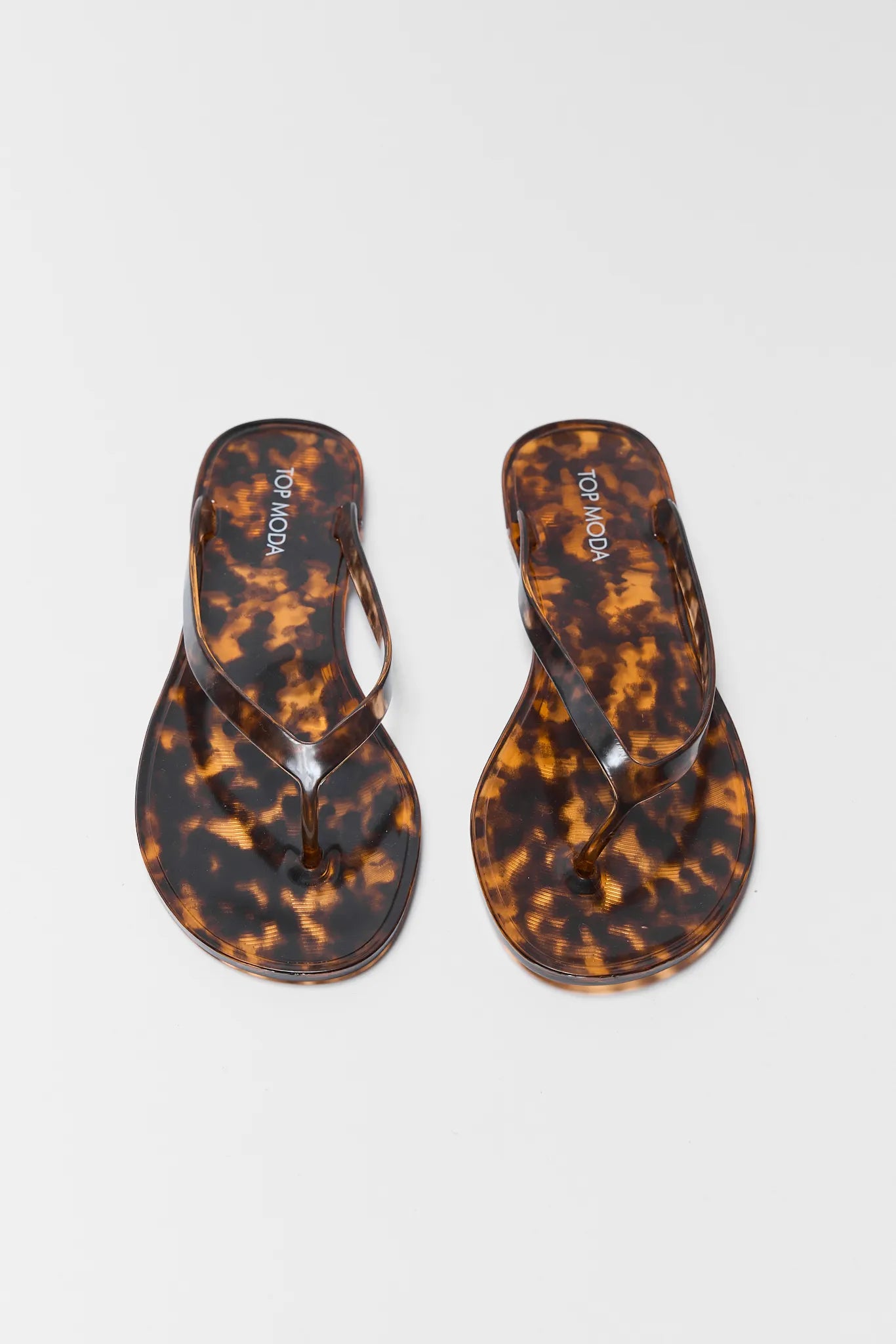 Tortoiseshell flip-flops on a white background
