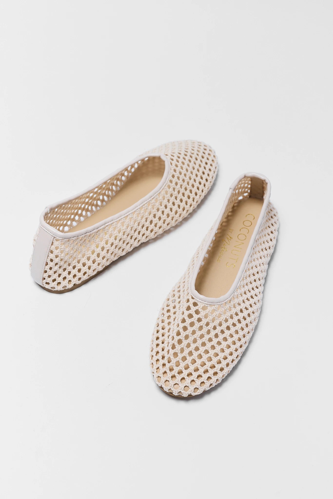 two Pair of beige perforated shoes on a light gray background