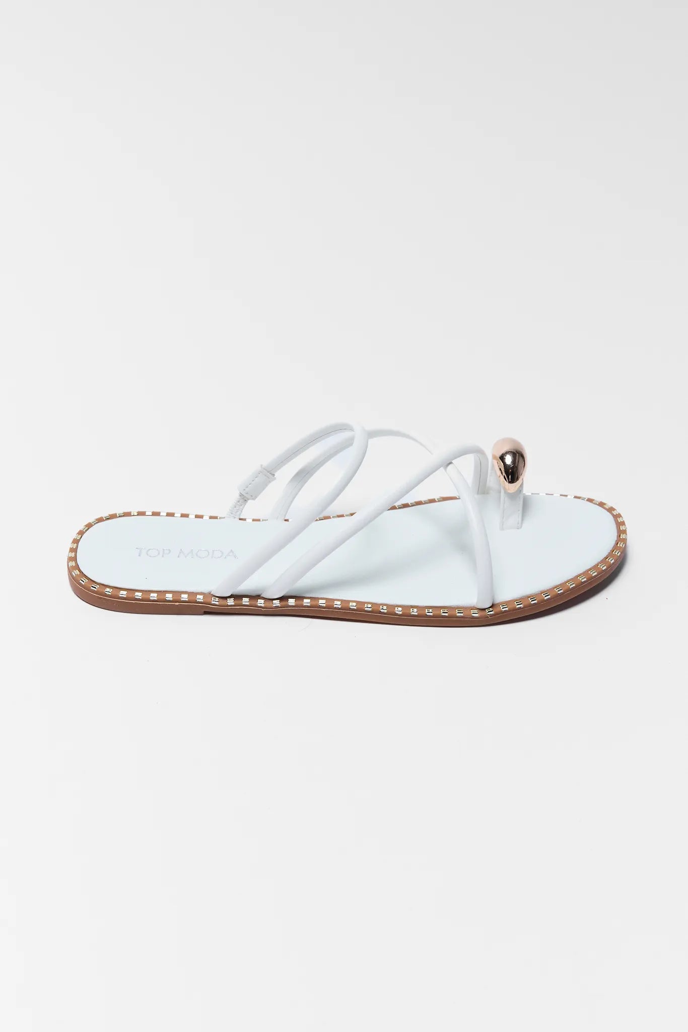 White sandal with brown sole on a light gray background