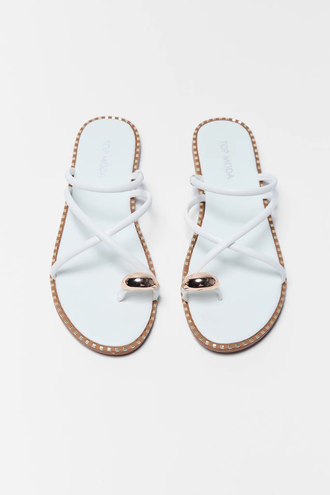 Pair of light sandals with gold accents on a white background