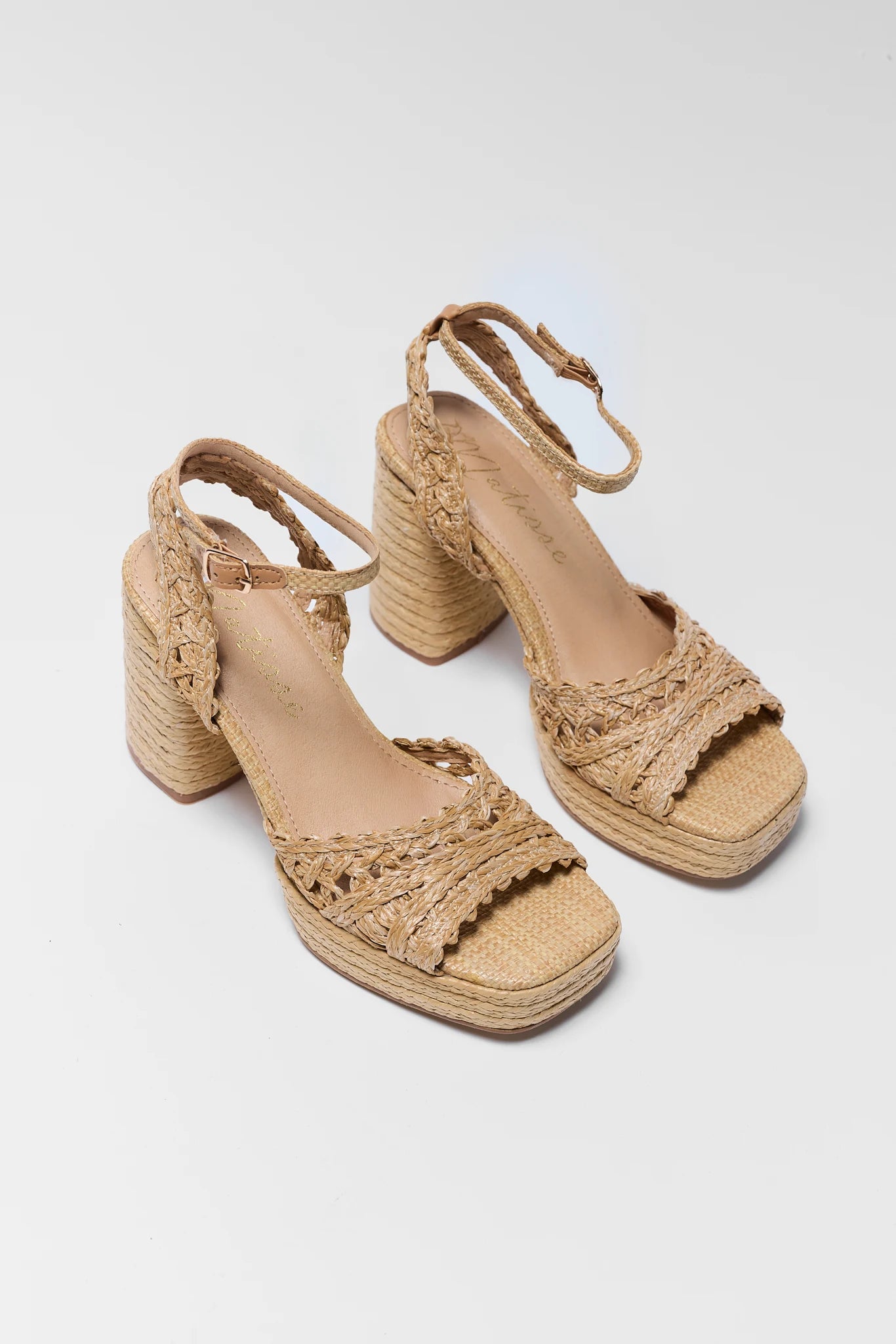 two Beige woven sandals on a light gray background